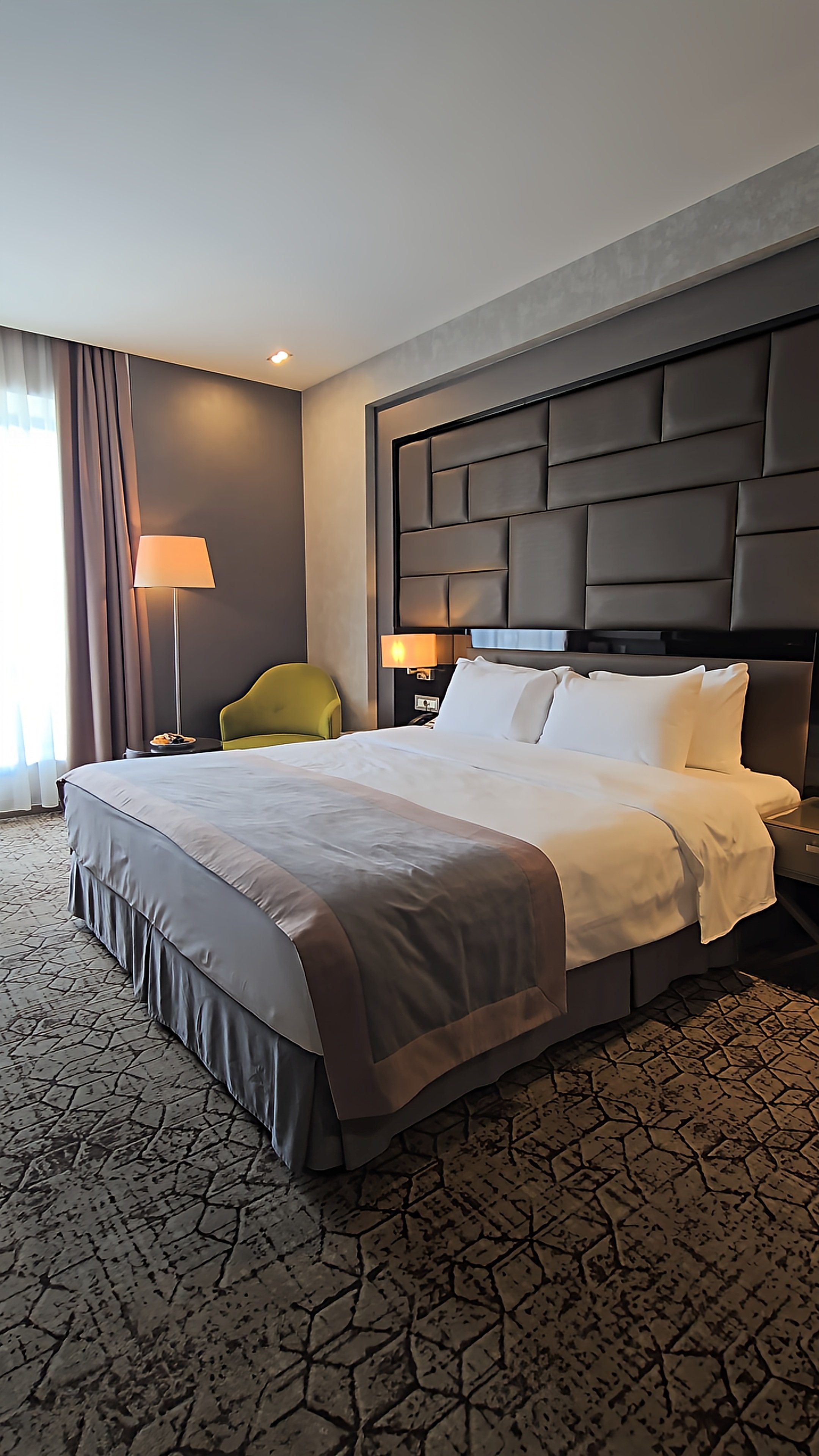 Spacious luxury guest room with a king bed, contemporary furnishings, and warm ambient lighting