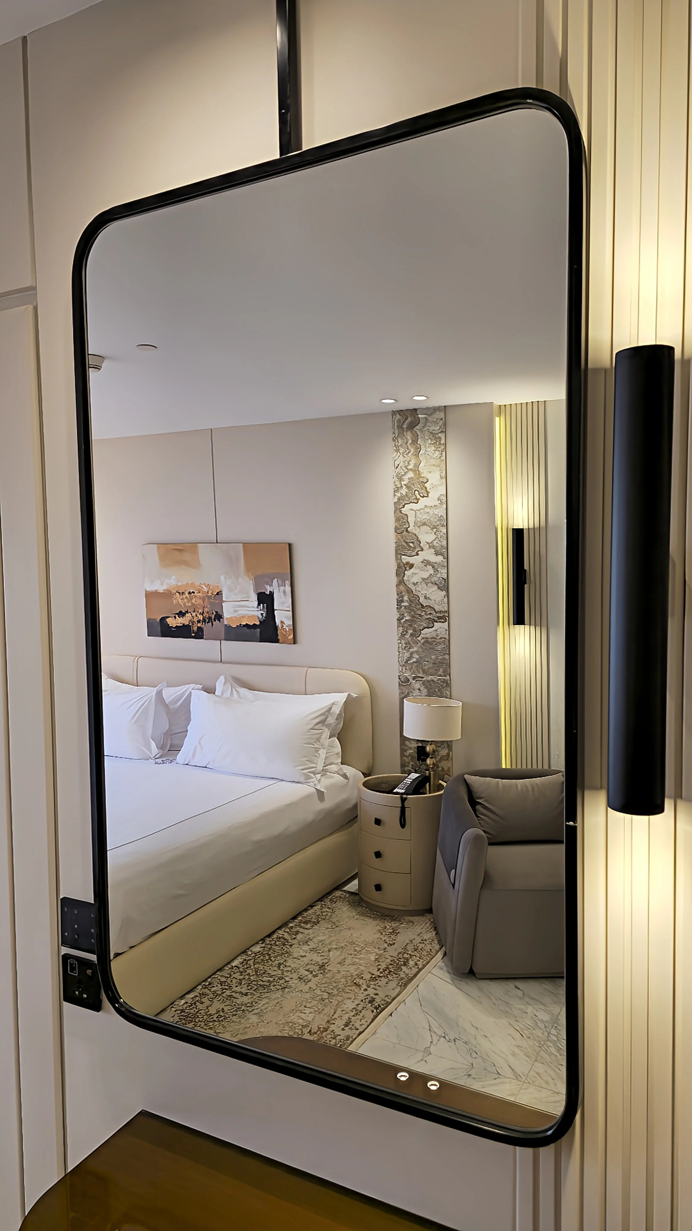 Contemporary suite reflected in a full-length mirror with sophisticated interior design
