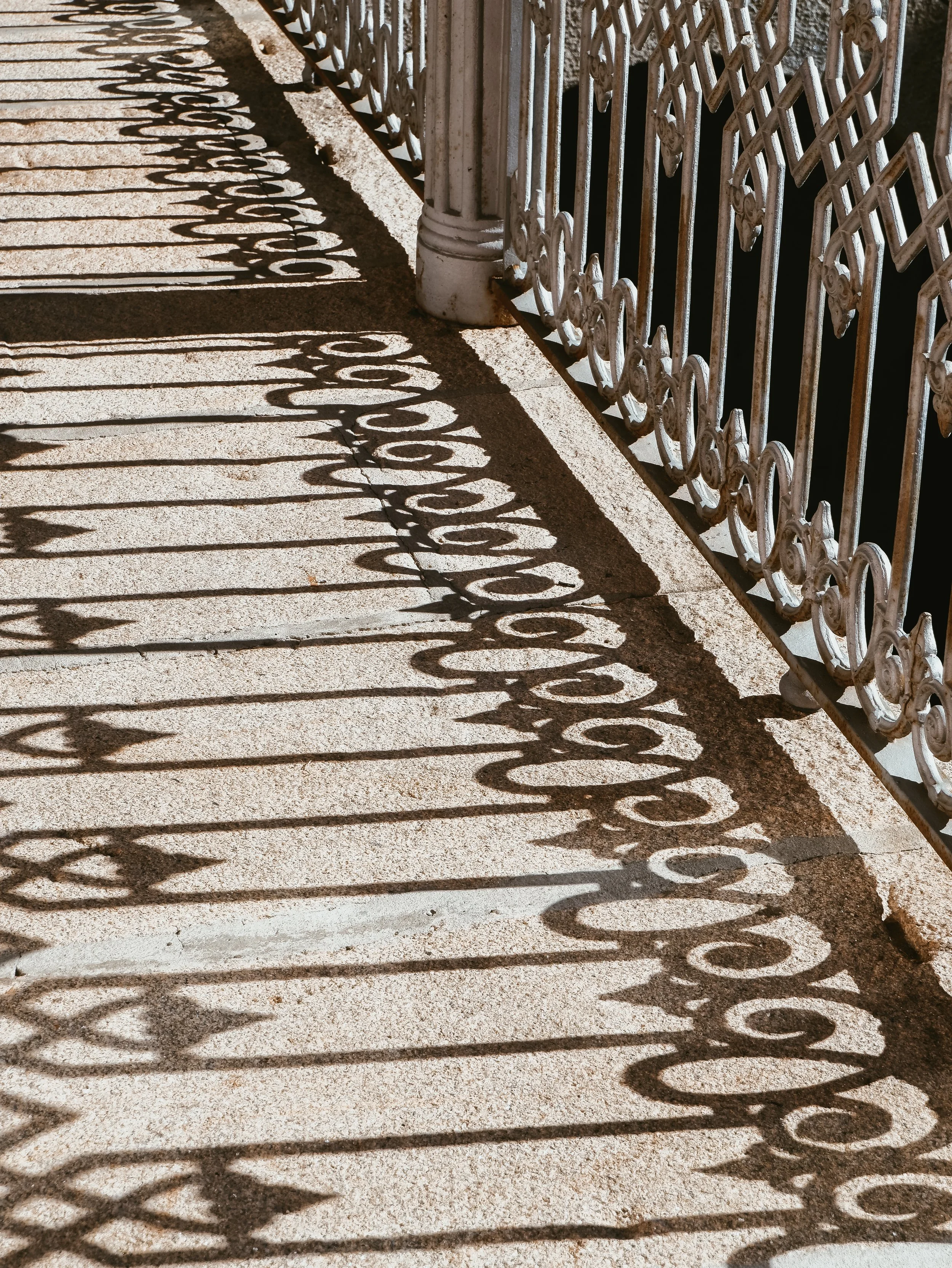 Sunlit terrace with ornate railing casting shadows across stone flooring, blending classic architecture and outdoor charm, Casas Novas Countryside Hotel Spa & Events – Chaves, Portugal.