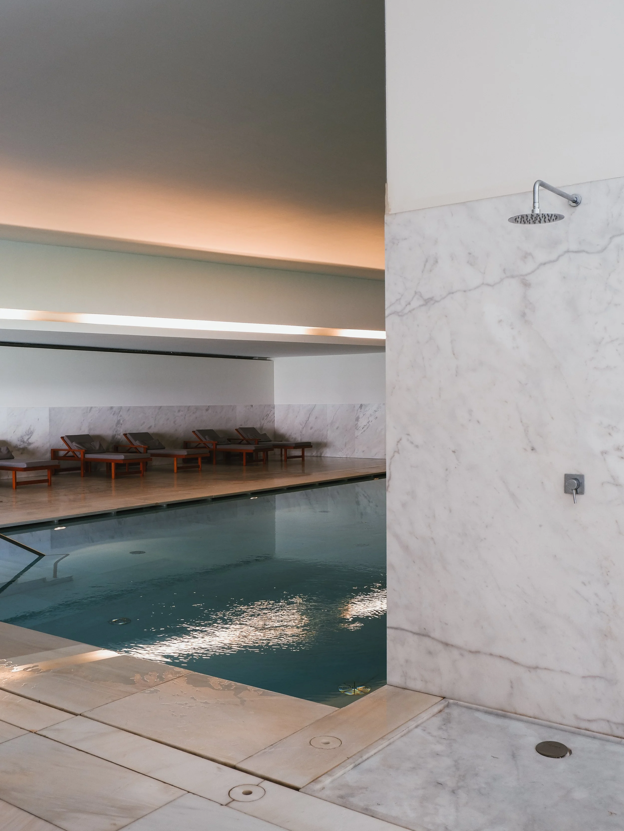 Contemporary indoor spa pool with marble finishes, relaxation loungers, and wellness facilities