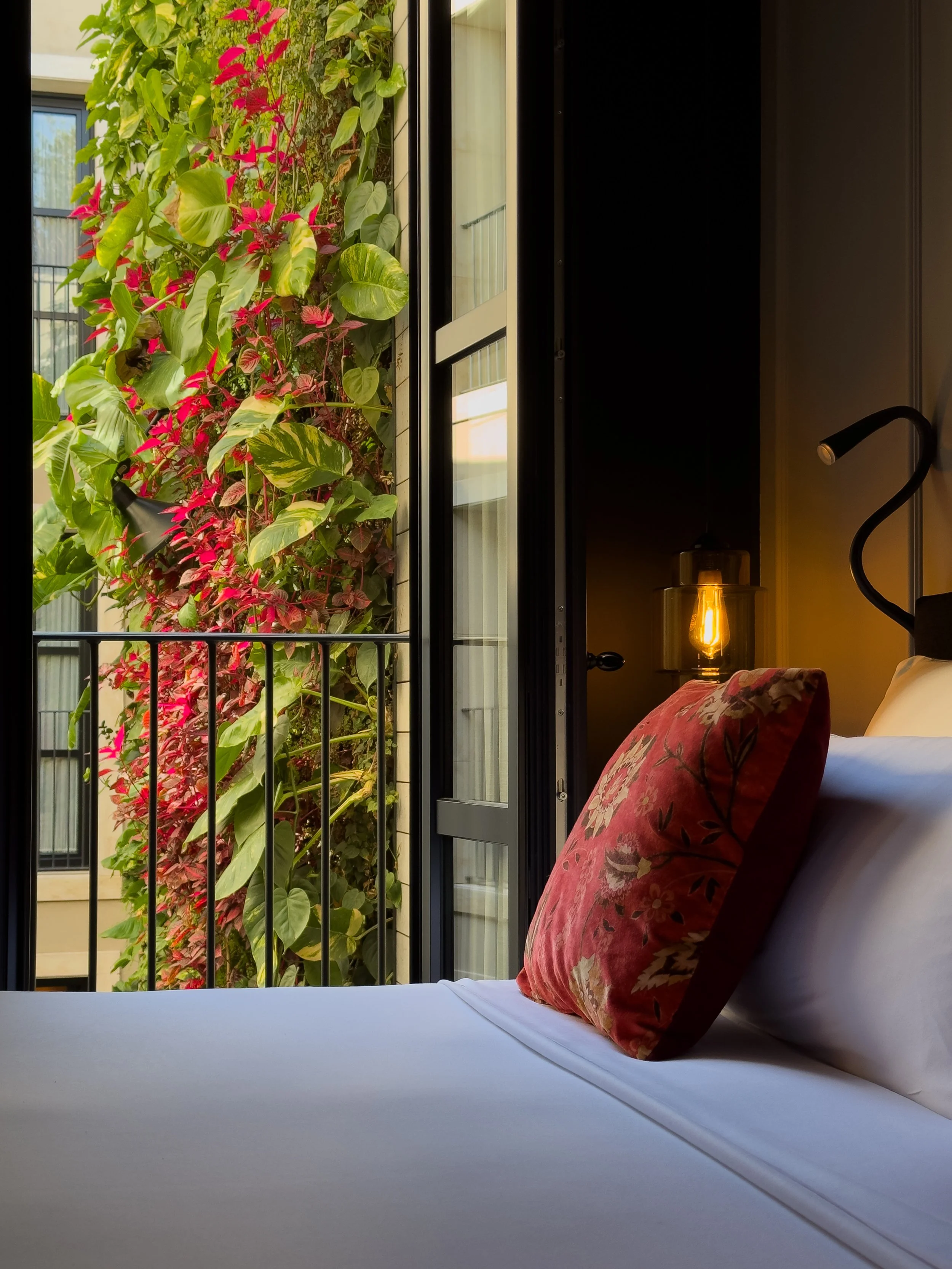 Luxury guest room overlooking Wittmore Hotel’s lush vertical garden courtyard in Barcelona’s Gothic Quarter