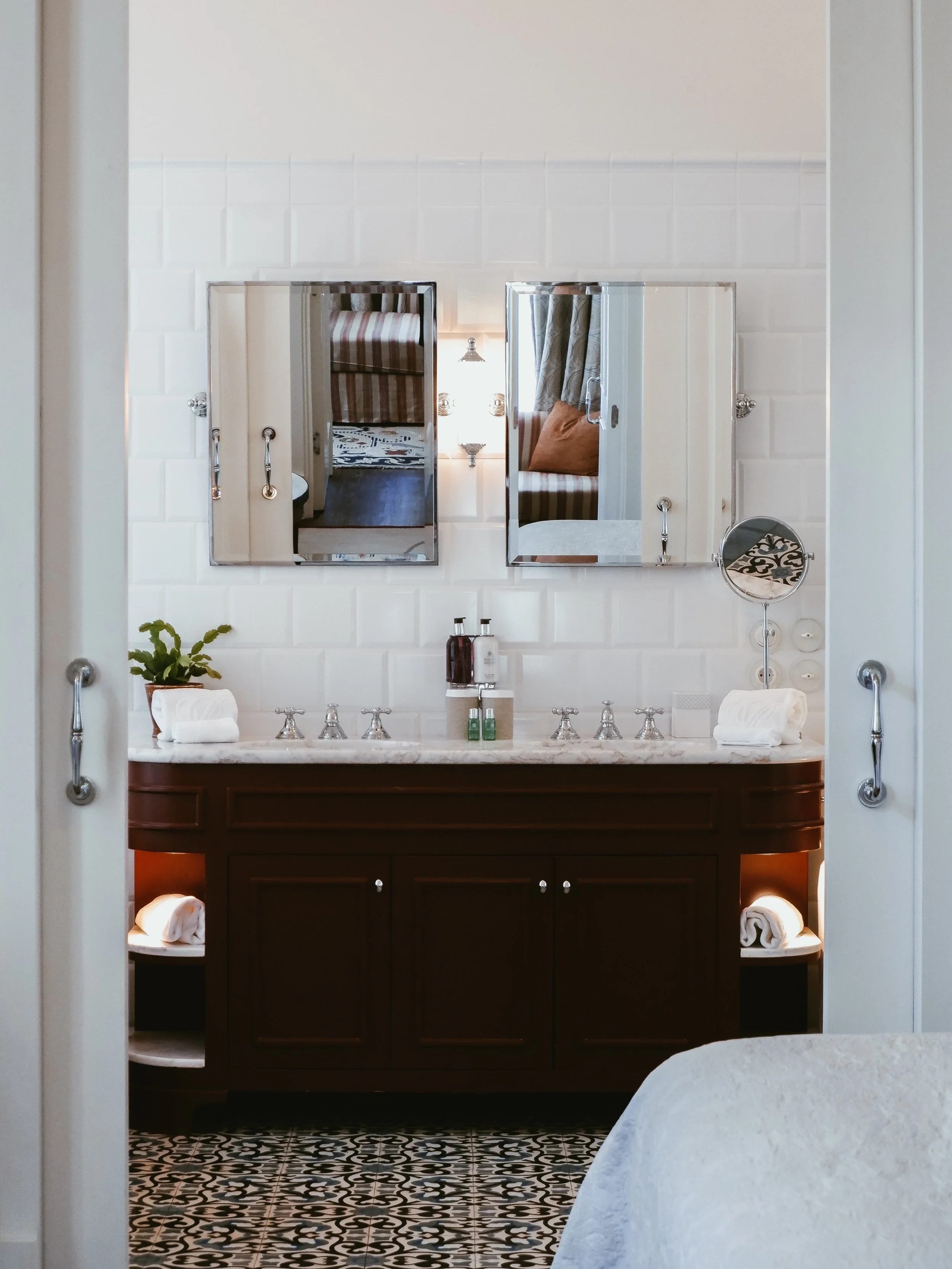Spacious marble bathroom with double vanity, classic mirrors, and premium luxury hotel amenities