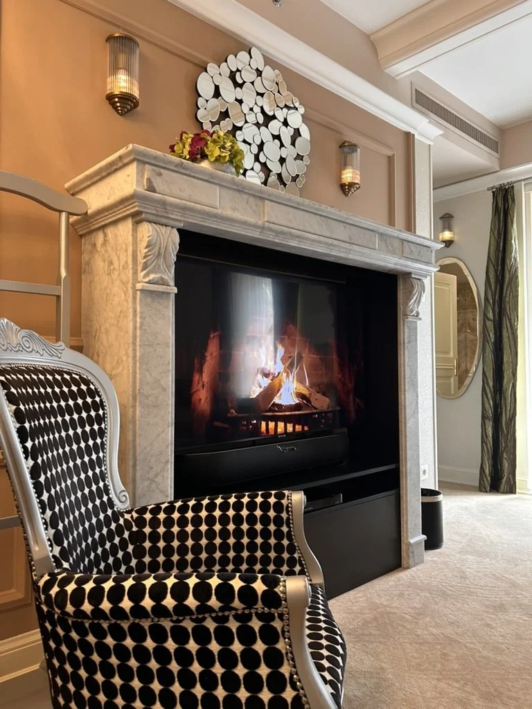 Luxurious suite featuring a marble fireplace and elegant lounge seating