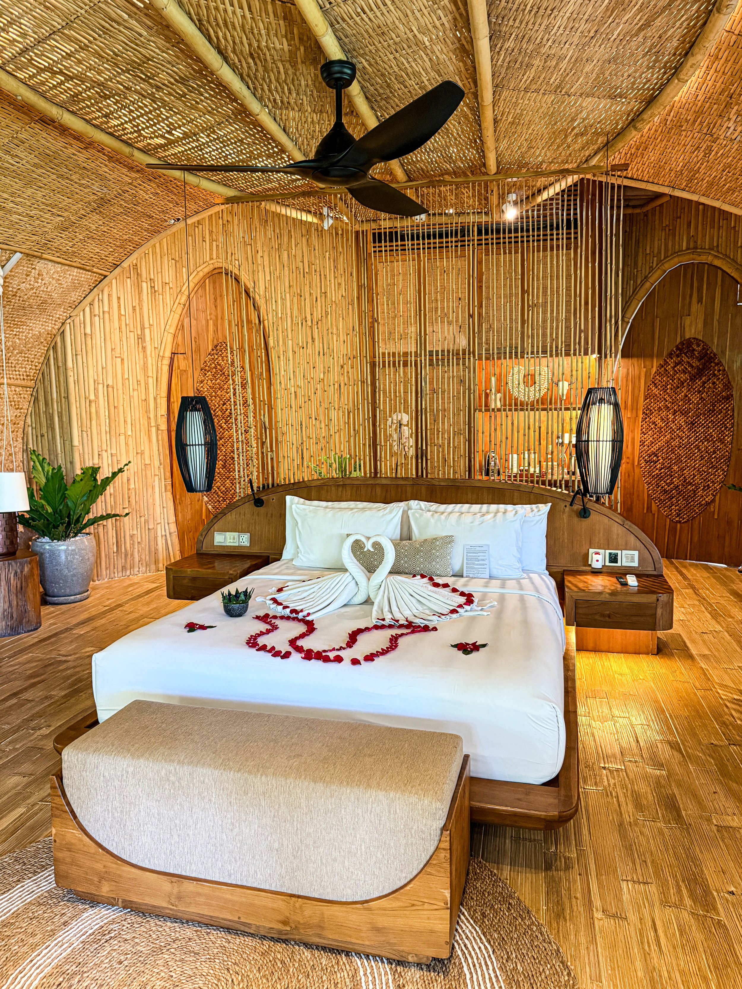 A spacious bamboo guest room blends handcrafted design, natural textures, and warm timber interiors for a refined tropical retreat