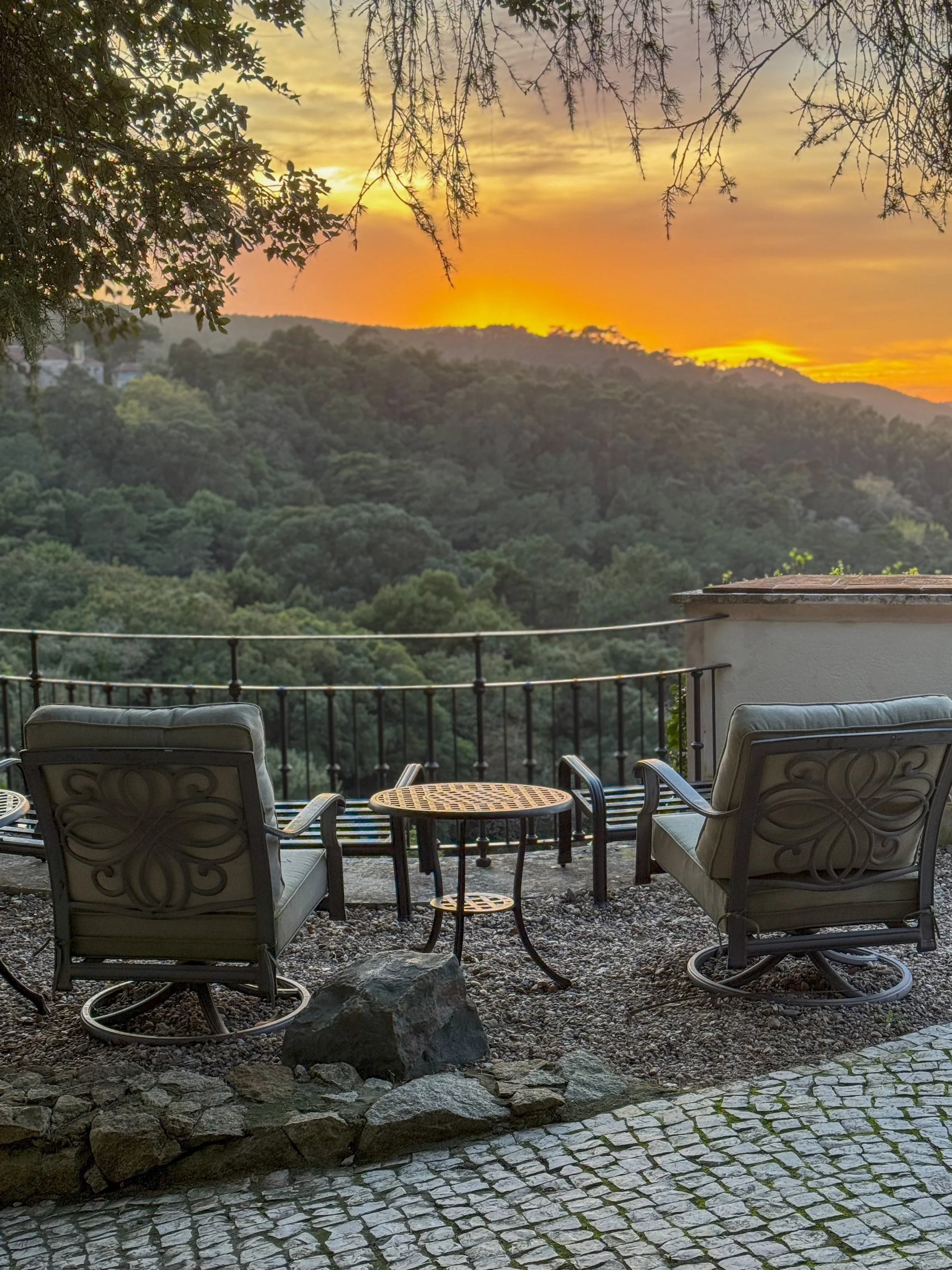 A quiet garden terrace faces the forested hills at golden hour