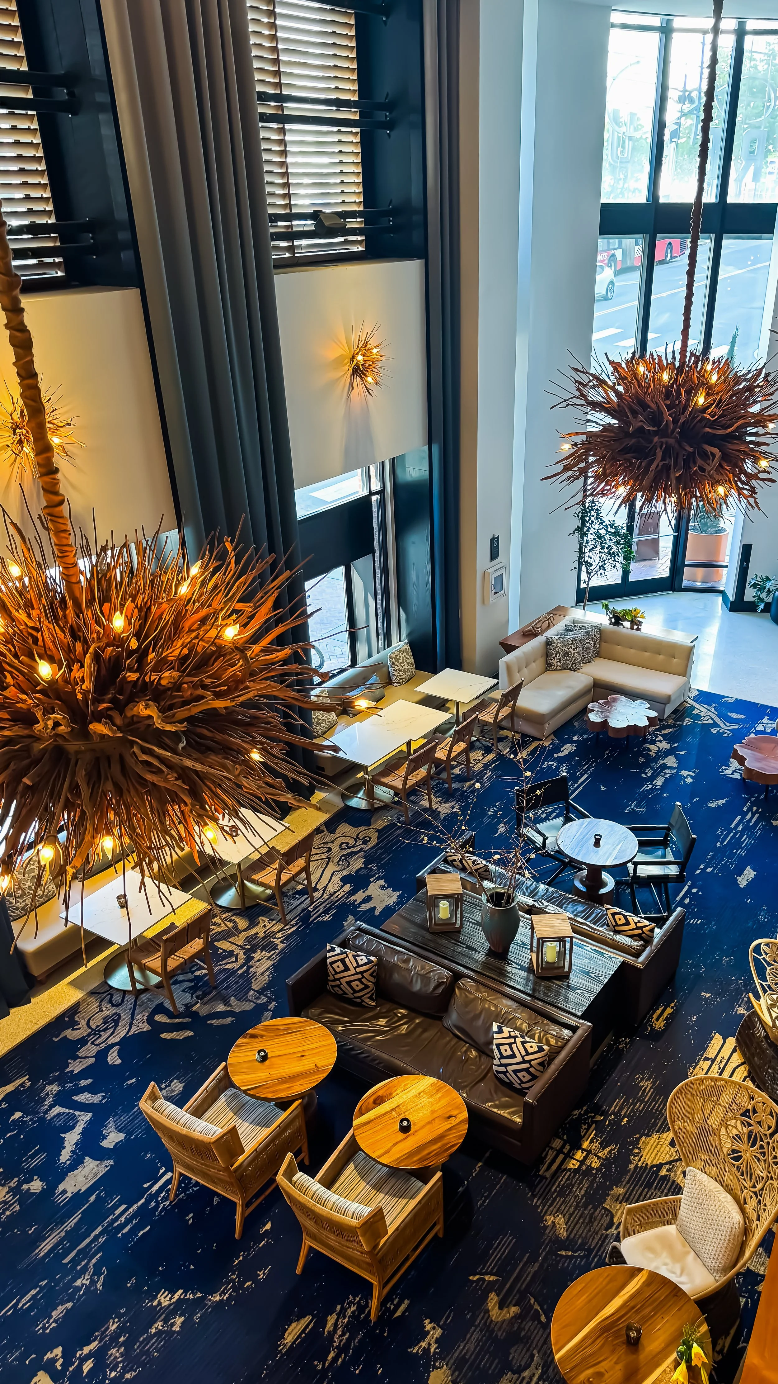 Elevated view across the dramatic lobby showcasing contemporary design, artistic lighting, and inviting gathering spaces