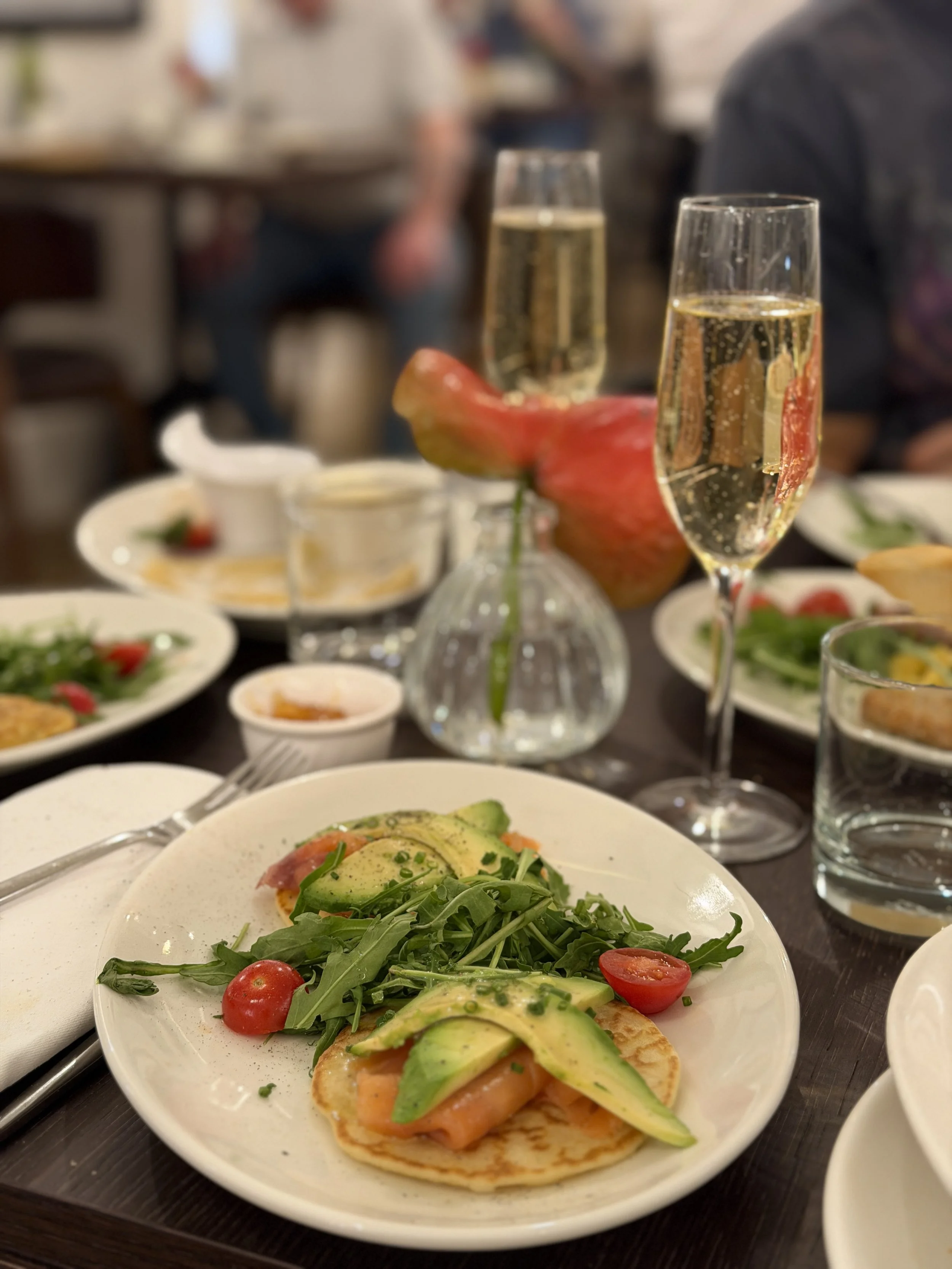 Fresh breakfast featuring smoked salmon, avocado, seasonal ingredients, and sparkling wine