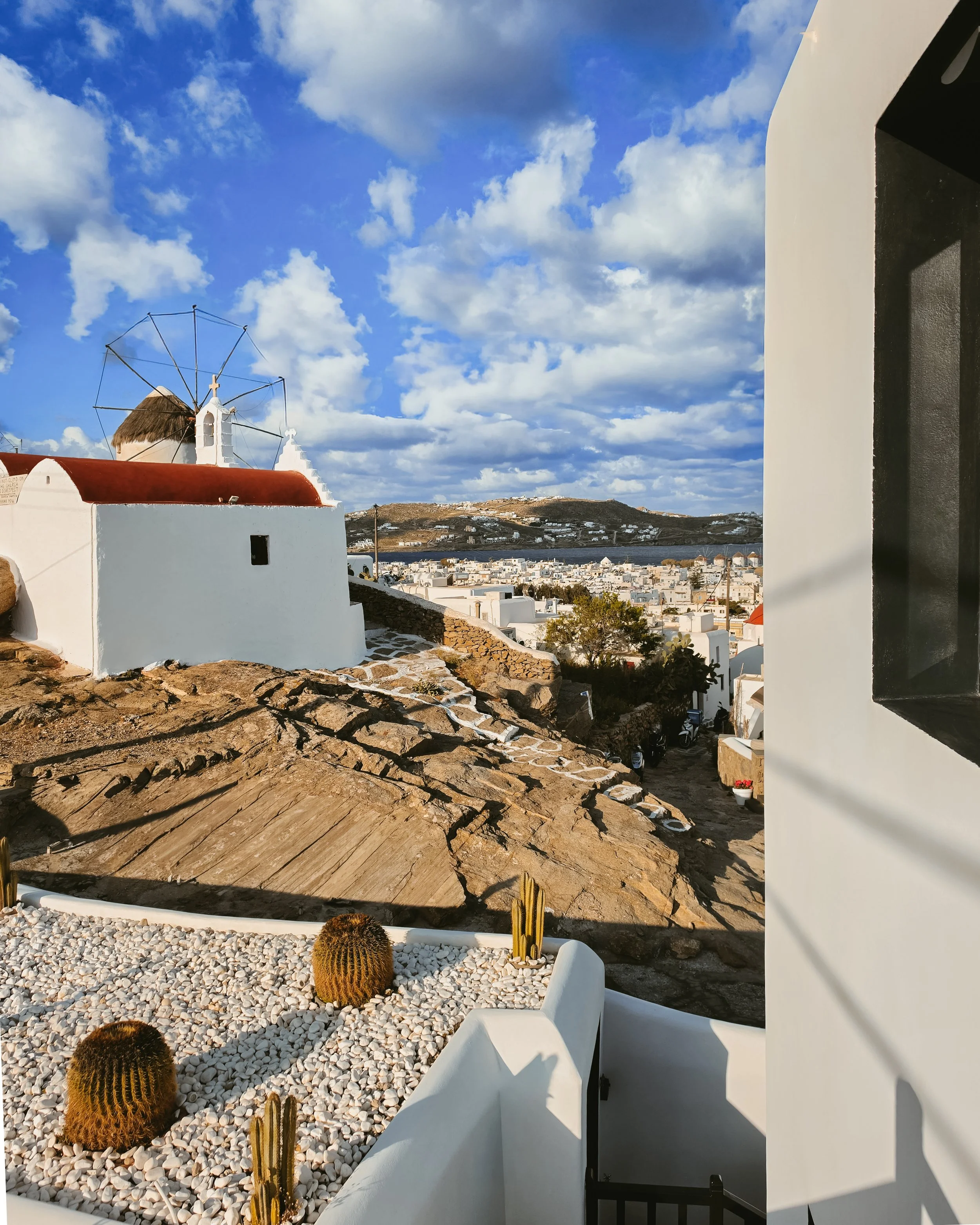 Traditional Mykonos windmill overlooking the charming whitewashed town and the surrounding Aegean coastline