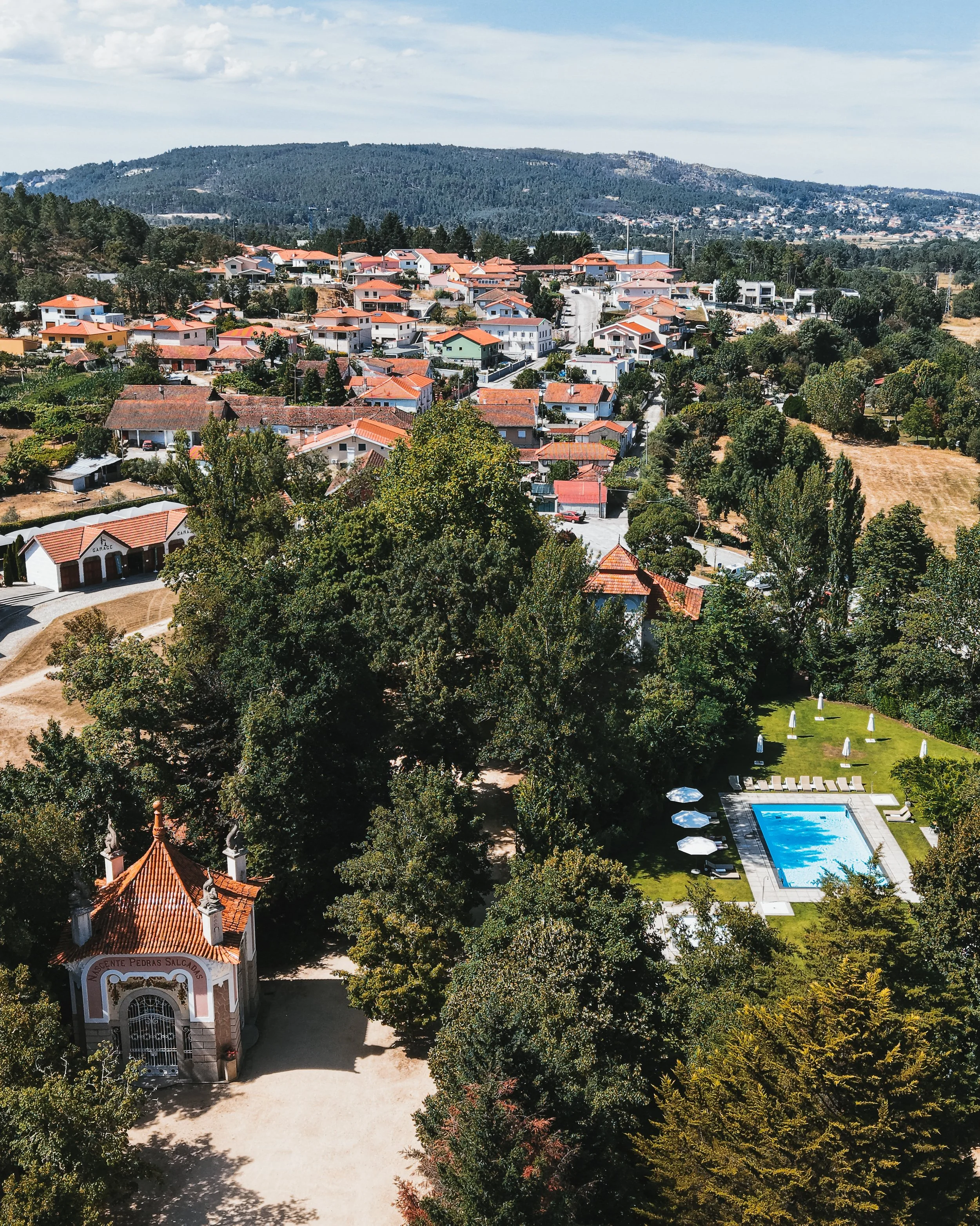 Panoramic view of the resort grounds framed by lush gardens and the village beyond
