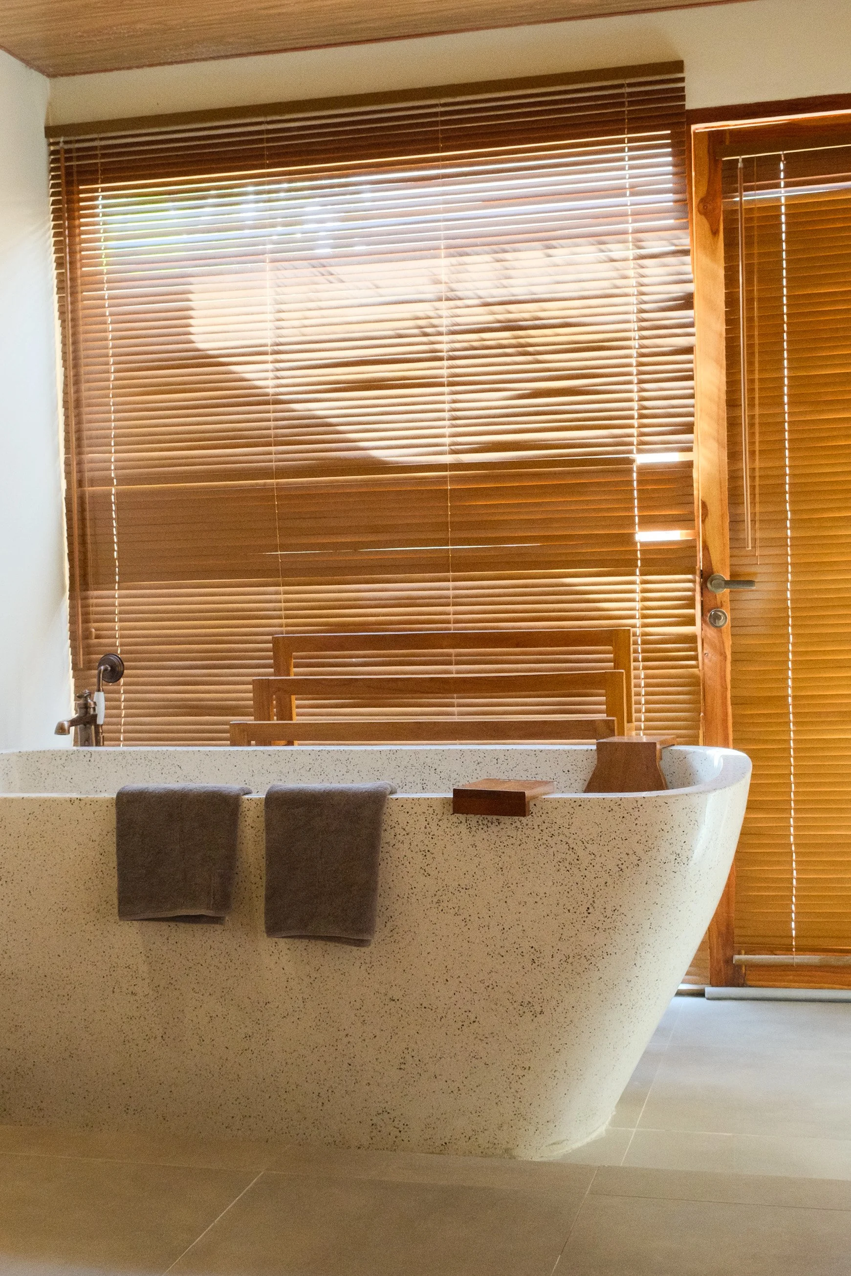 Freestanding stone bathtub bathed in warm natural morning light