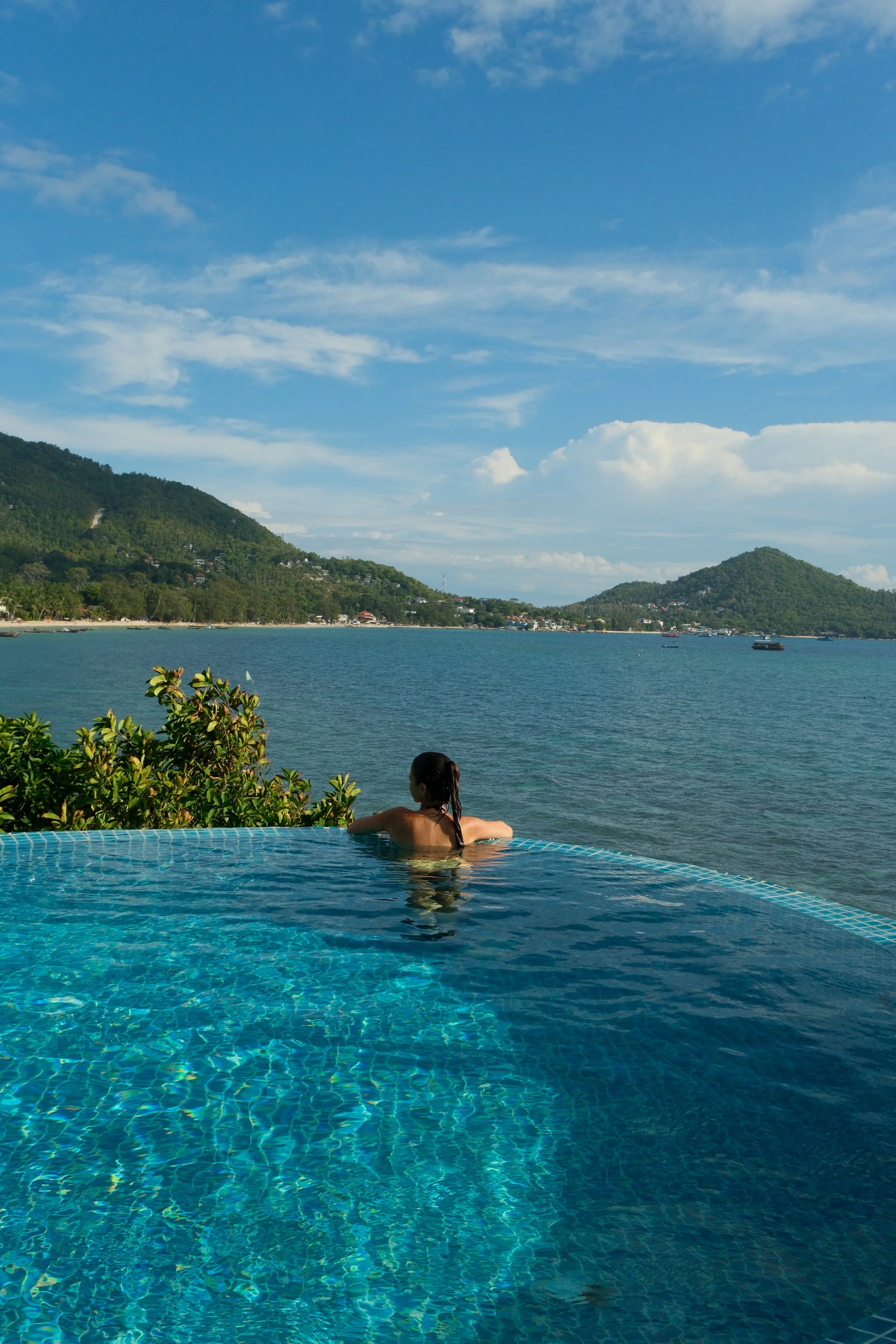 Infinity pool overlooking turquoise waters and the lush hills surrounding the bay