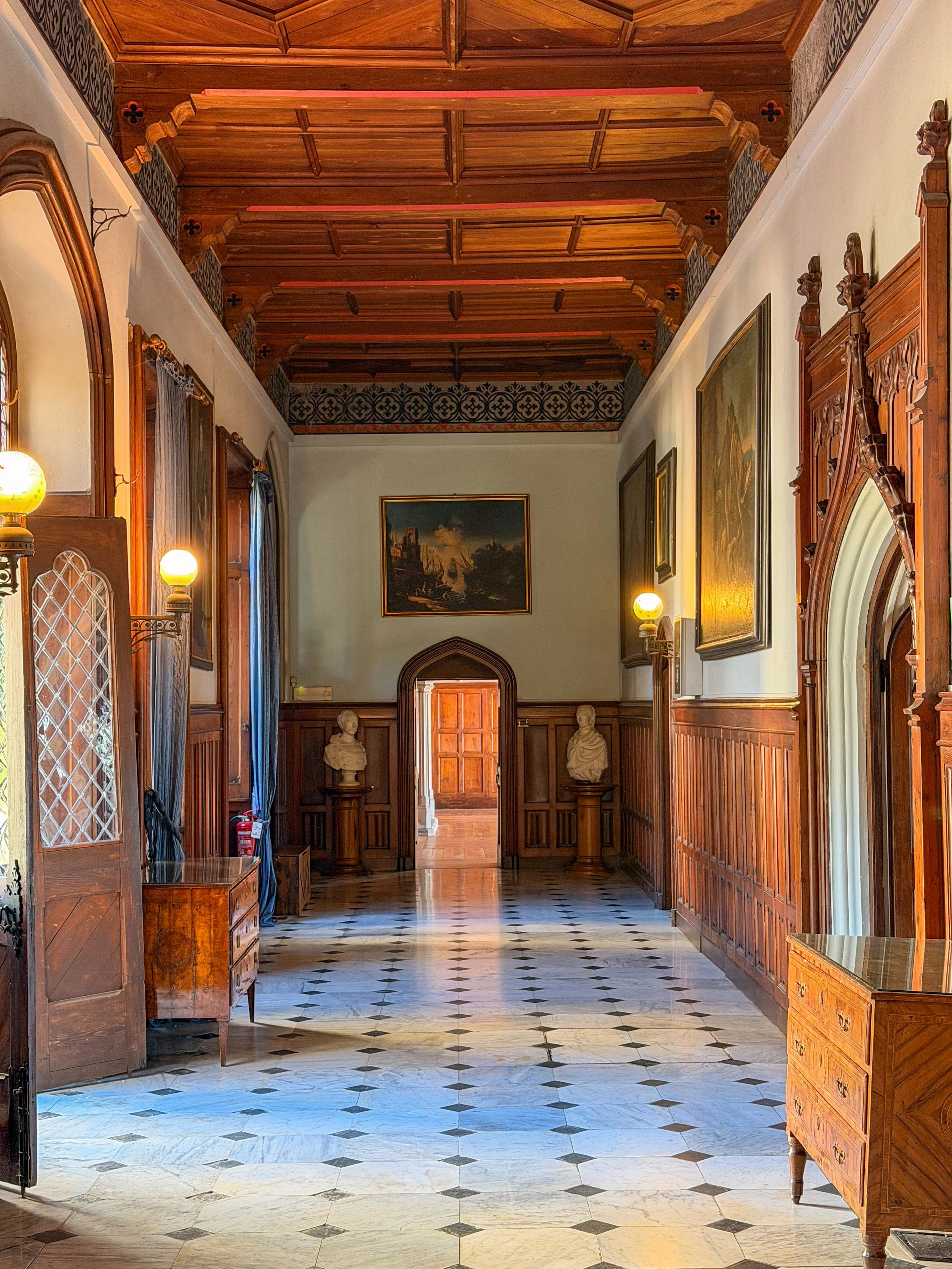 Grand historic corridor featuring handcrafted woodwork and original artwork