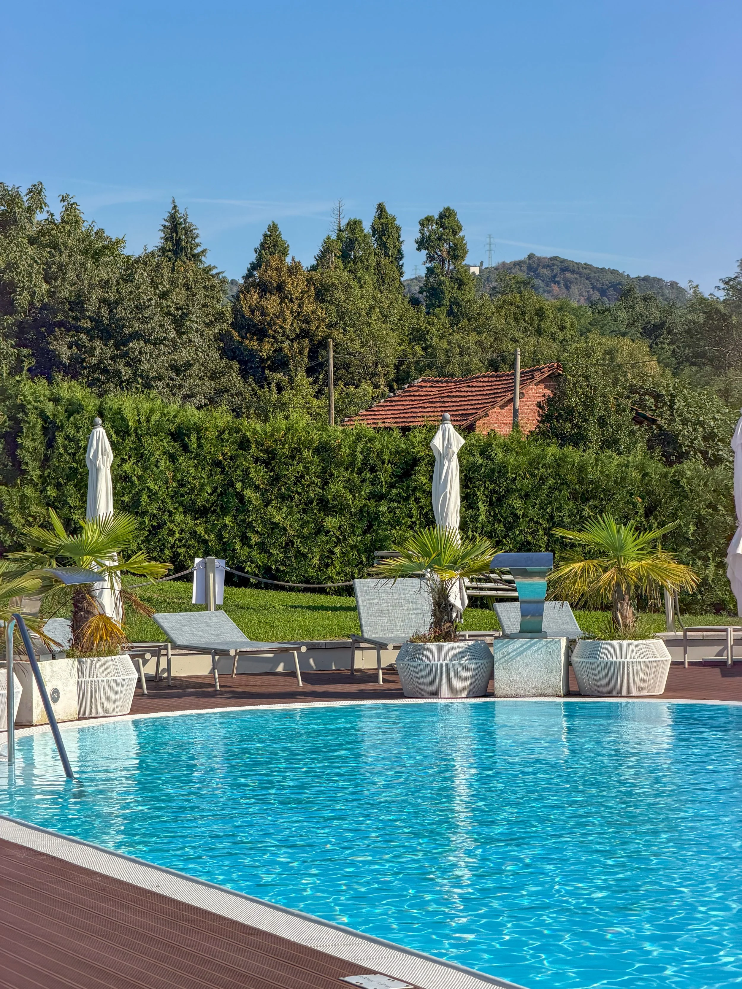 Outdoor swimming pool surrounded by gardens and peaceful countryside