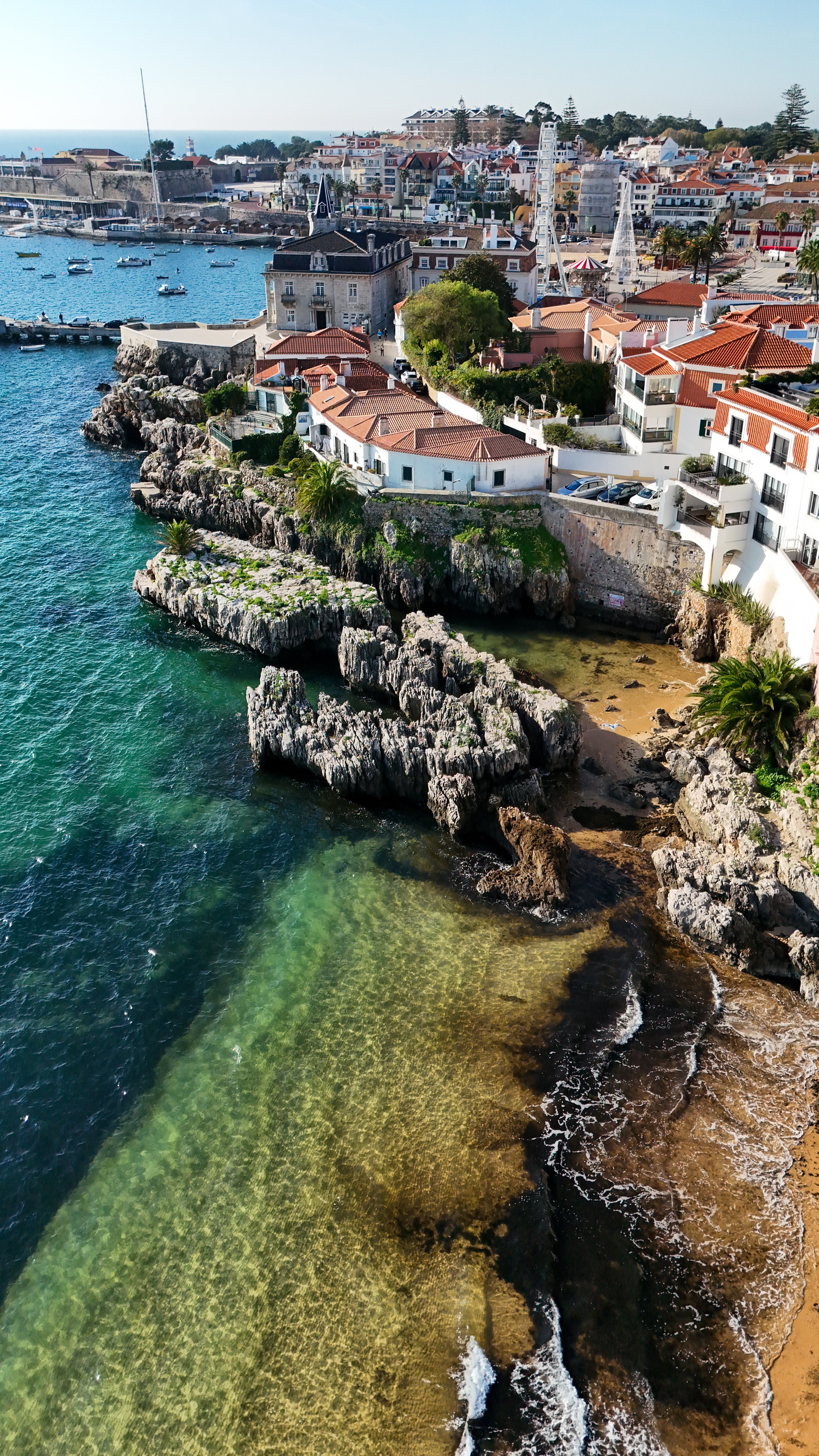 Drone view of Villa Cascais Boutique Hotel surrounded by Cascais Bay, historic streets, and crystal-clear waters