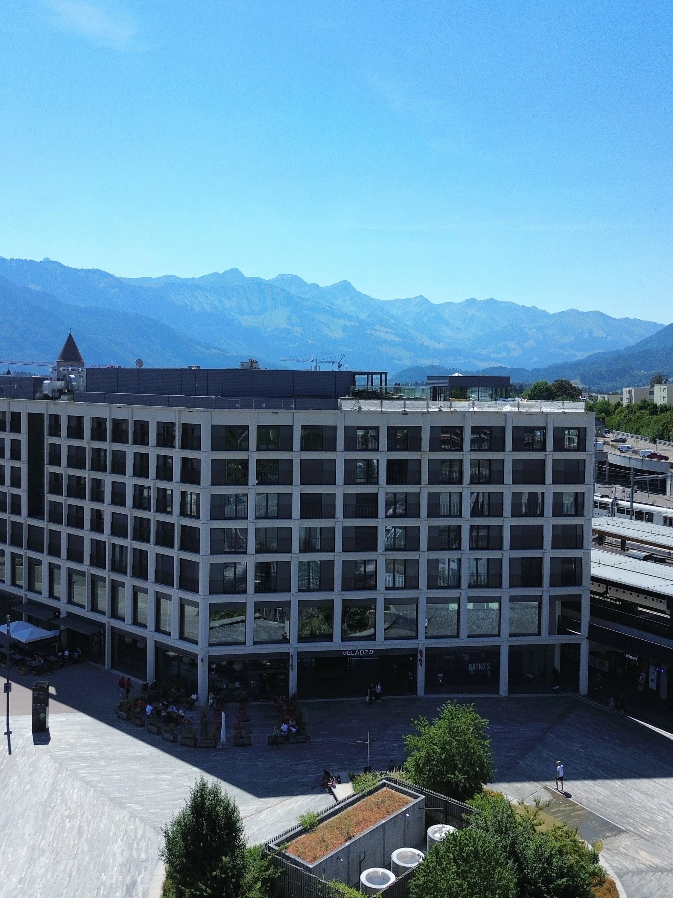 Drone view highlighting the contemporary hotel with the Swiss Alps rising in the background