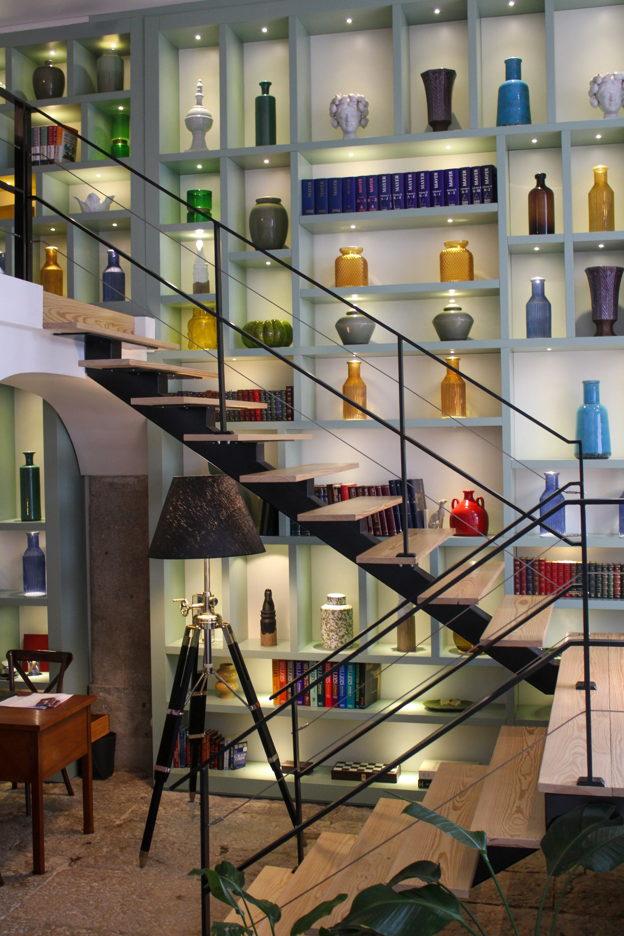 Library inspired social space with floor to ceiling shelving and curated décor at Once Upon Lisboa, Lisbon