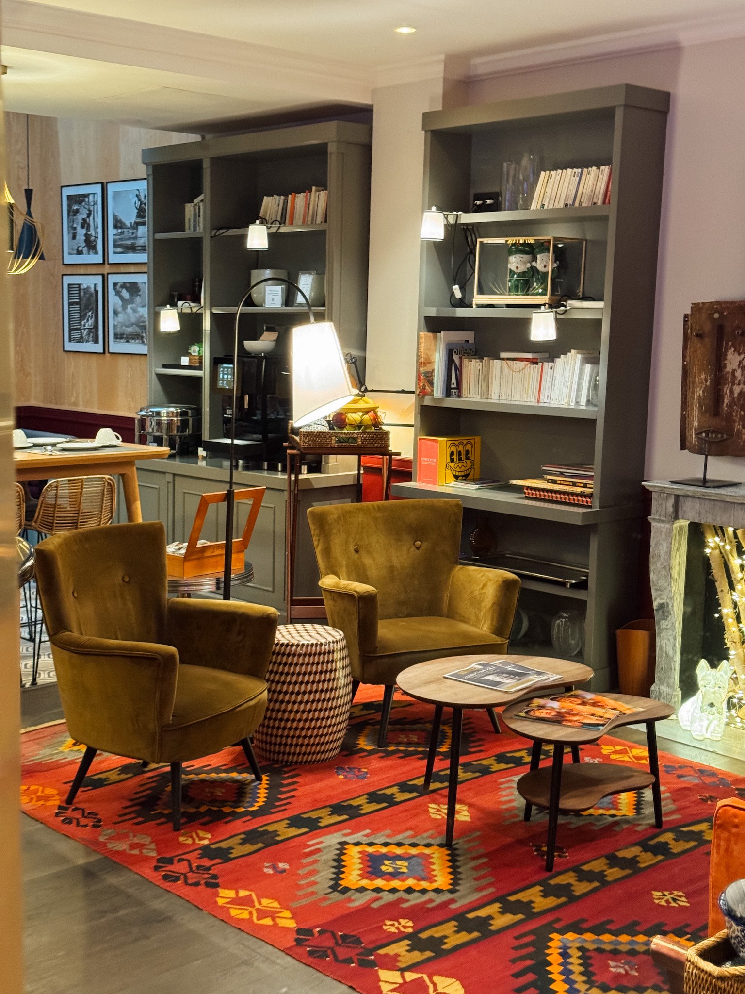 Cosy lounge with designer armchairs, curated bookshelves, and warm ambient lighting