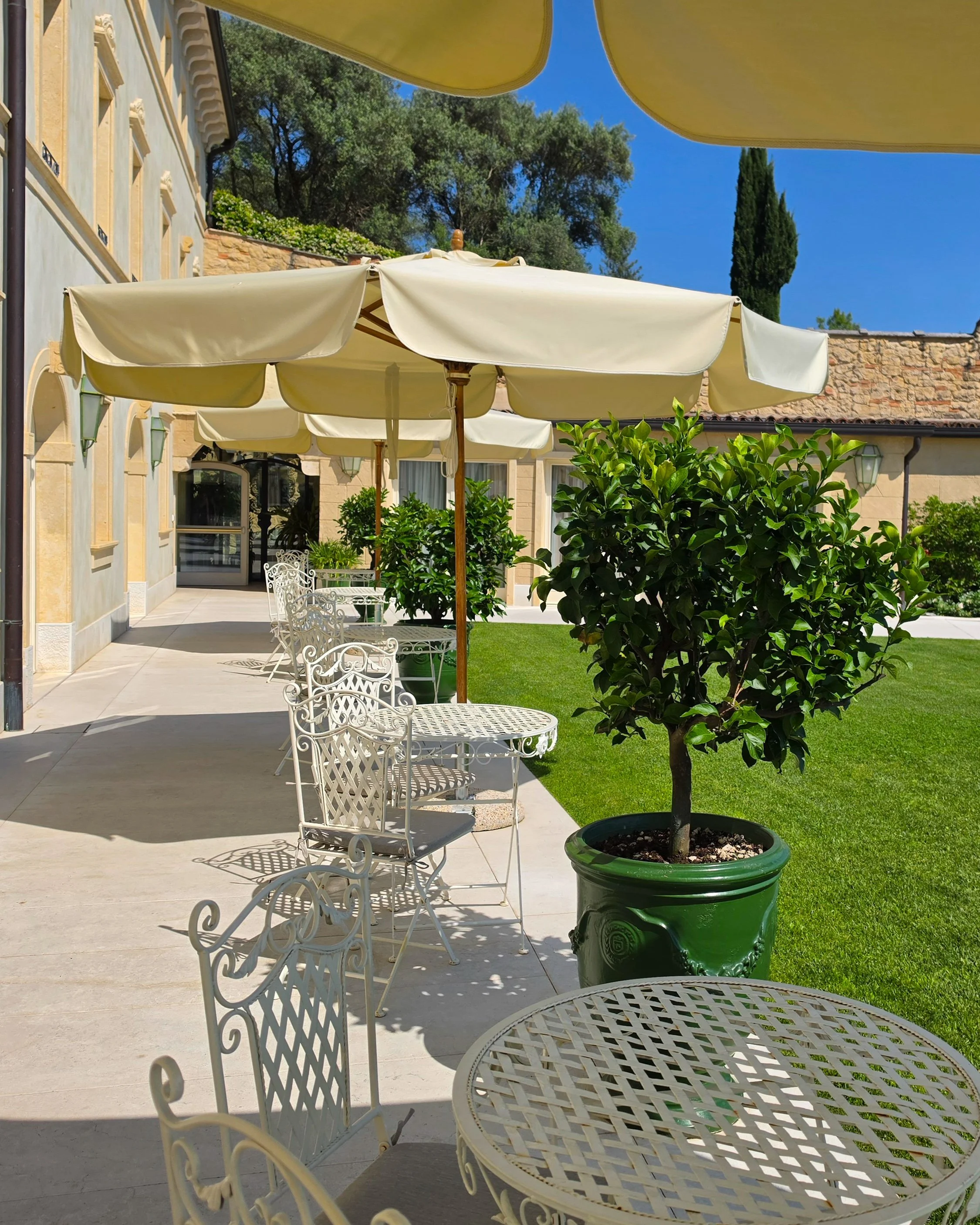 Peaceful garden terrace featuring elegant outdoor seating beside the historic villa at Relais Fra’ Lorenzo
