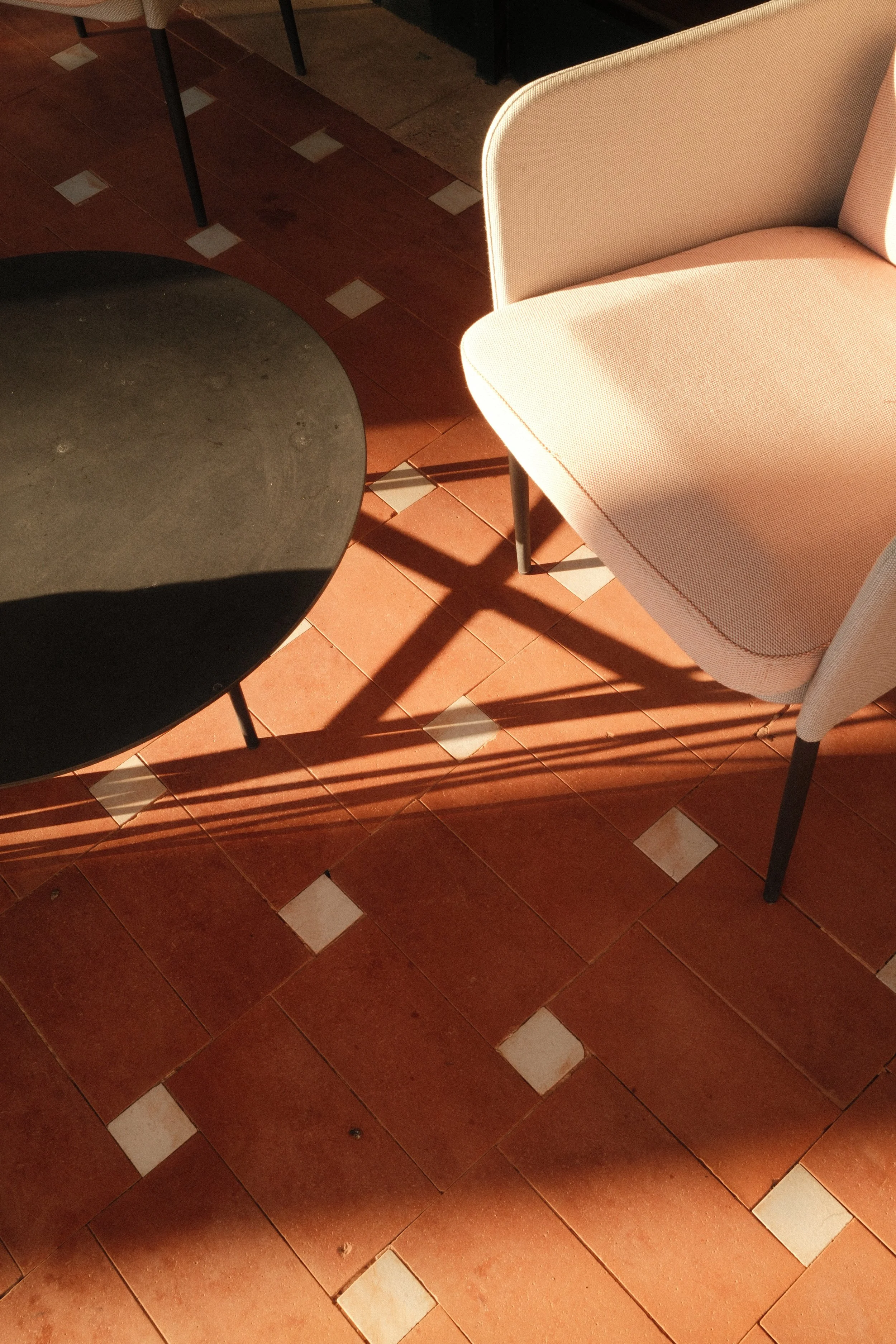 Elegant outdoor lounge featuring terracotta floors, soft sunlight and relaxed Mediterranean design at Hilton Mallorca Galatzo