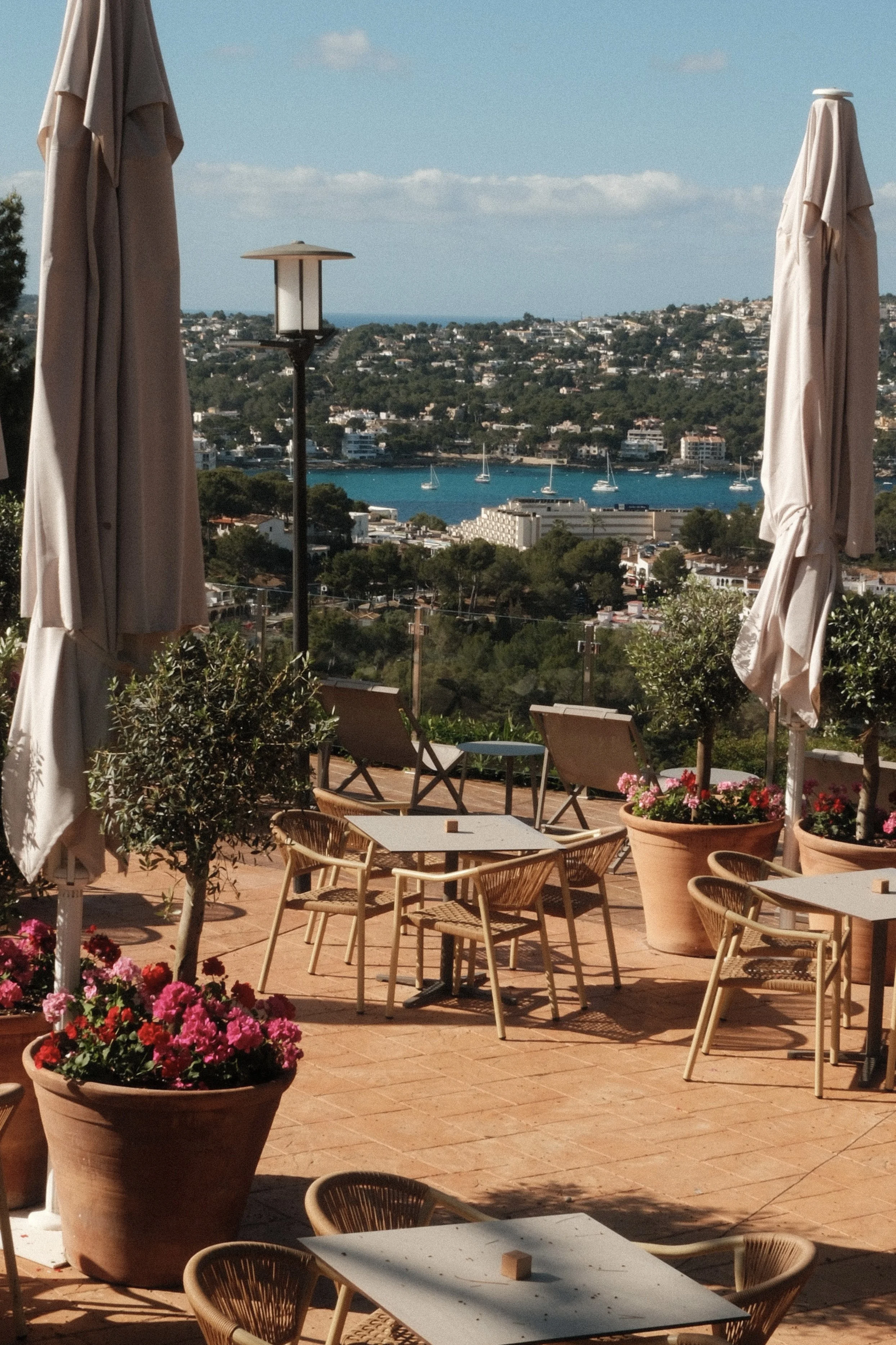 Scenic terrace dining area with sea views, Mediterranean landscaping and outdoor seating at Hilton Mallorca Galatzo