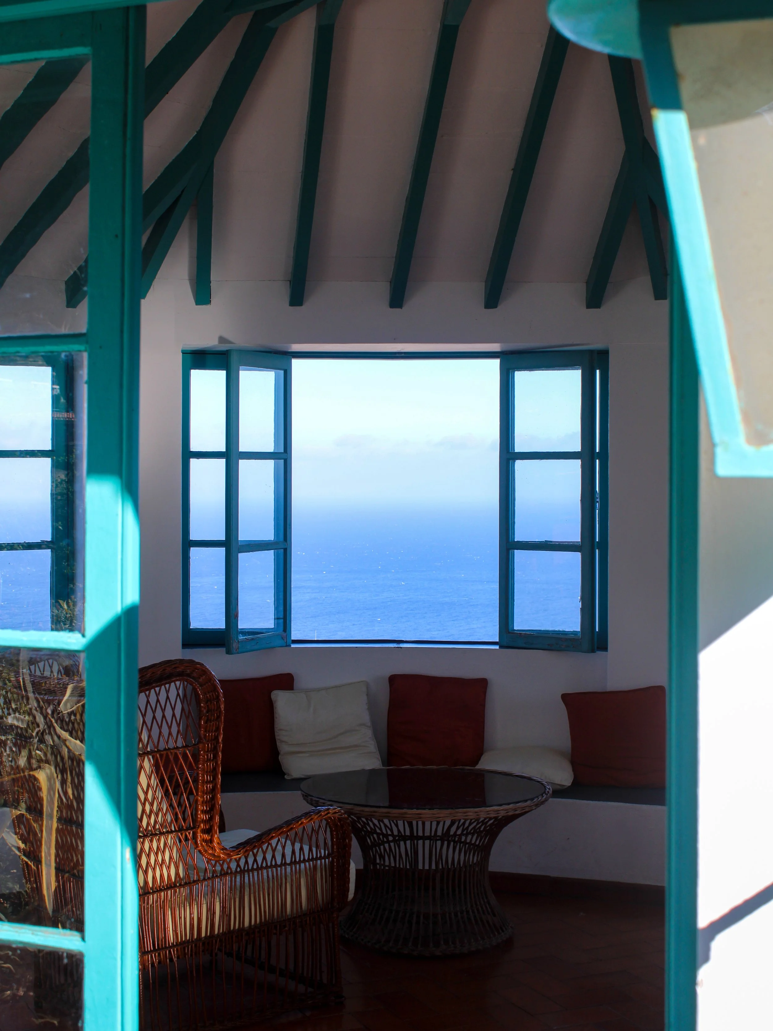 Ocean-view lounge framed by traditional windows, offering panoramic Atlantic scenery