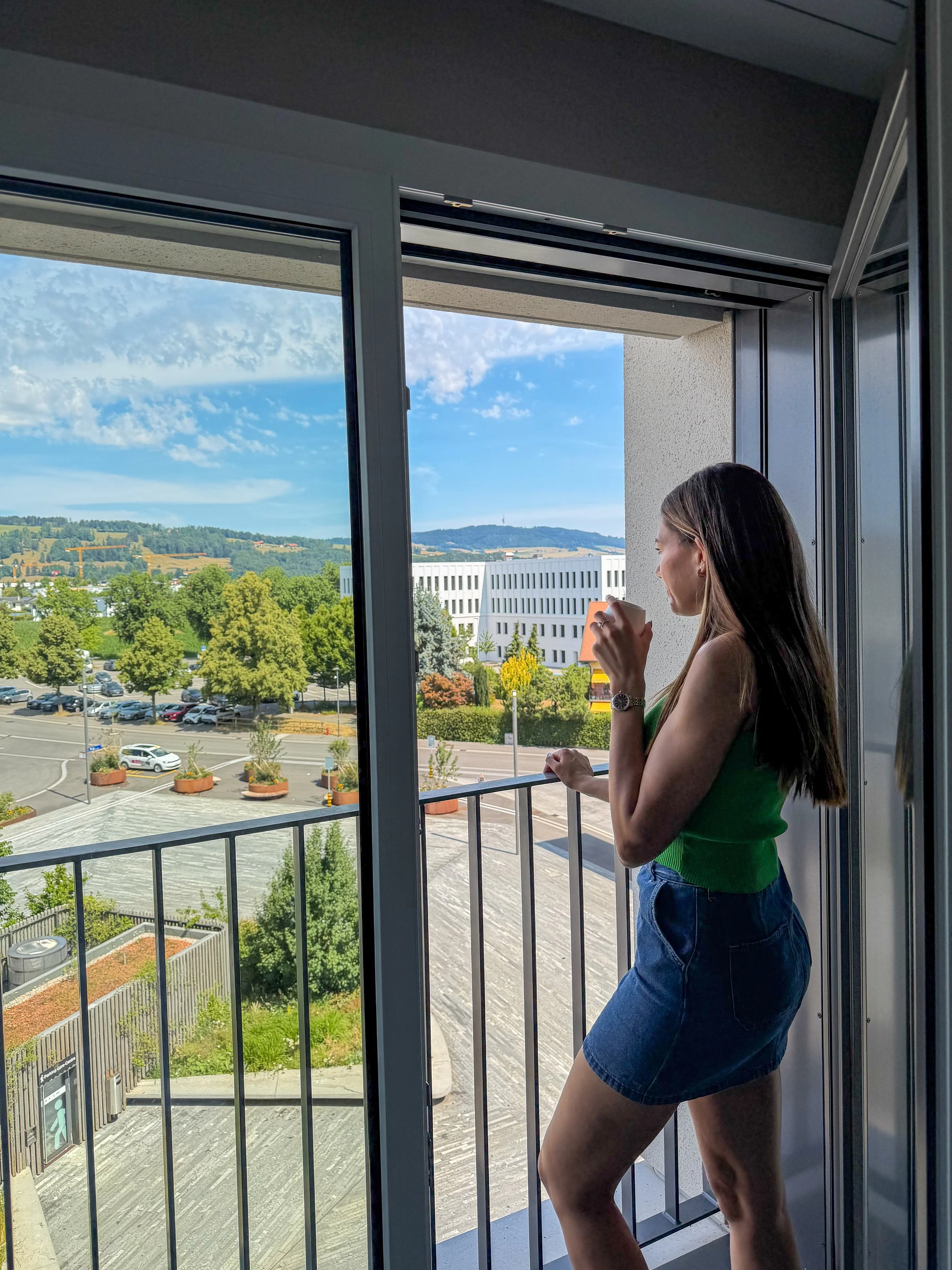 Guest enjoying a peaceful morning coffee while overlooking the surrounding Swiss landscapes
