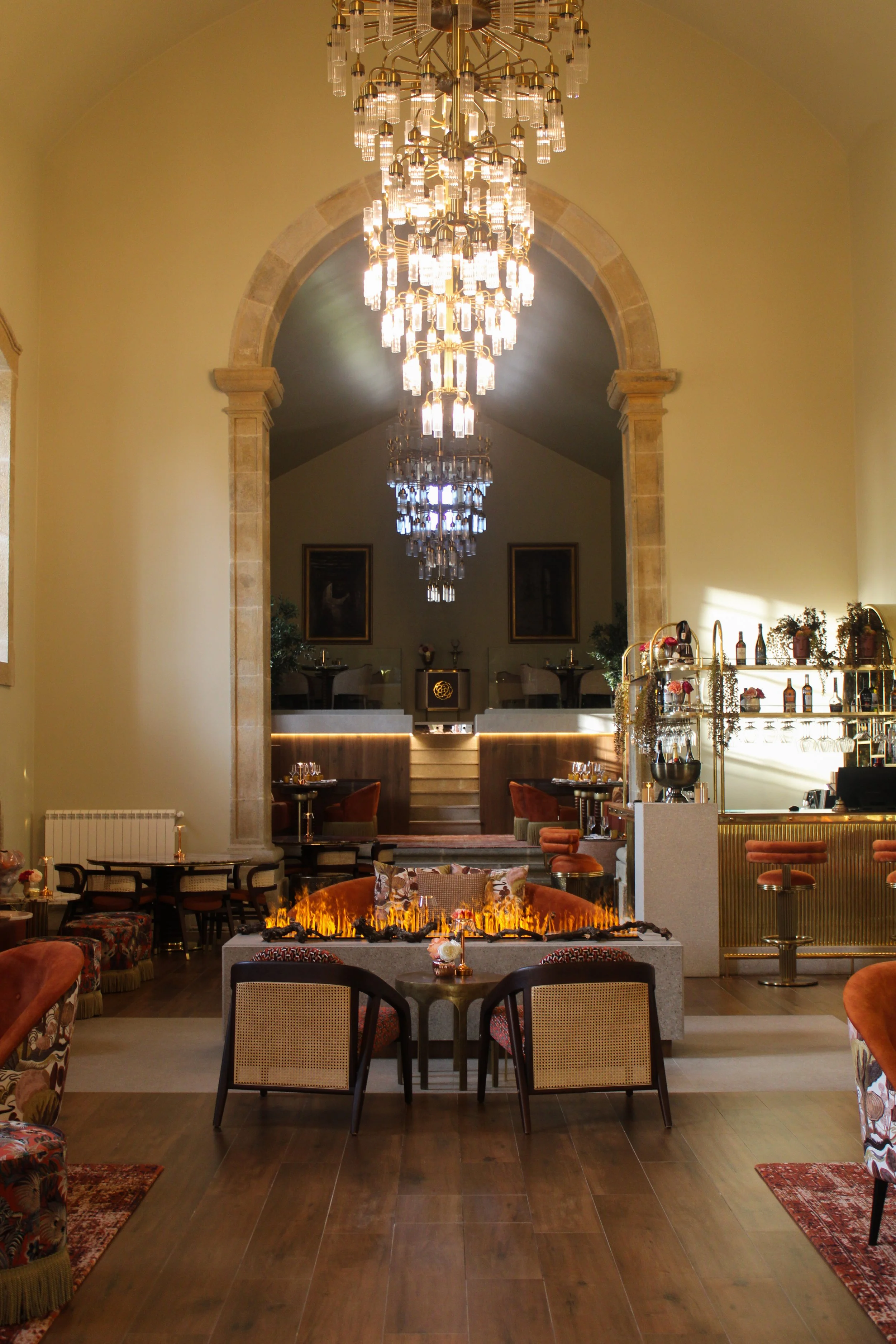 Sophisticated lounge with chandeliers, fireplace and warm interiors at Convento do Seixo, Portugal