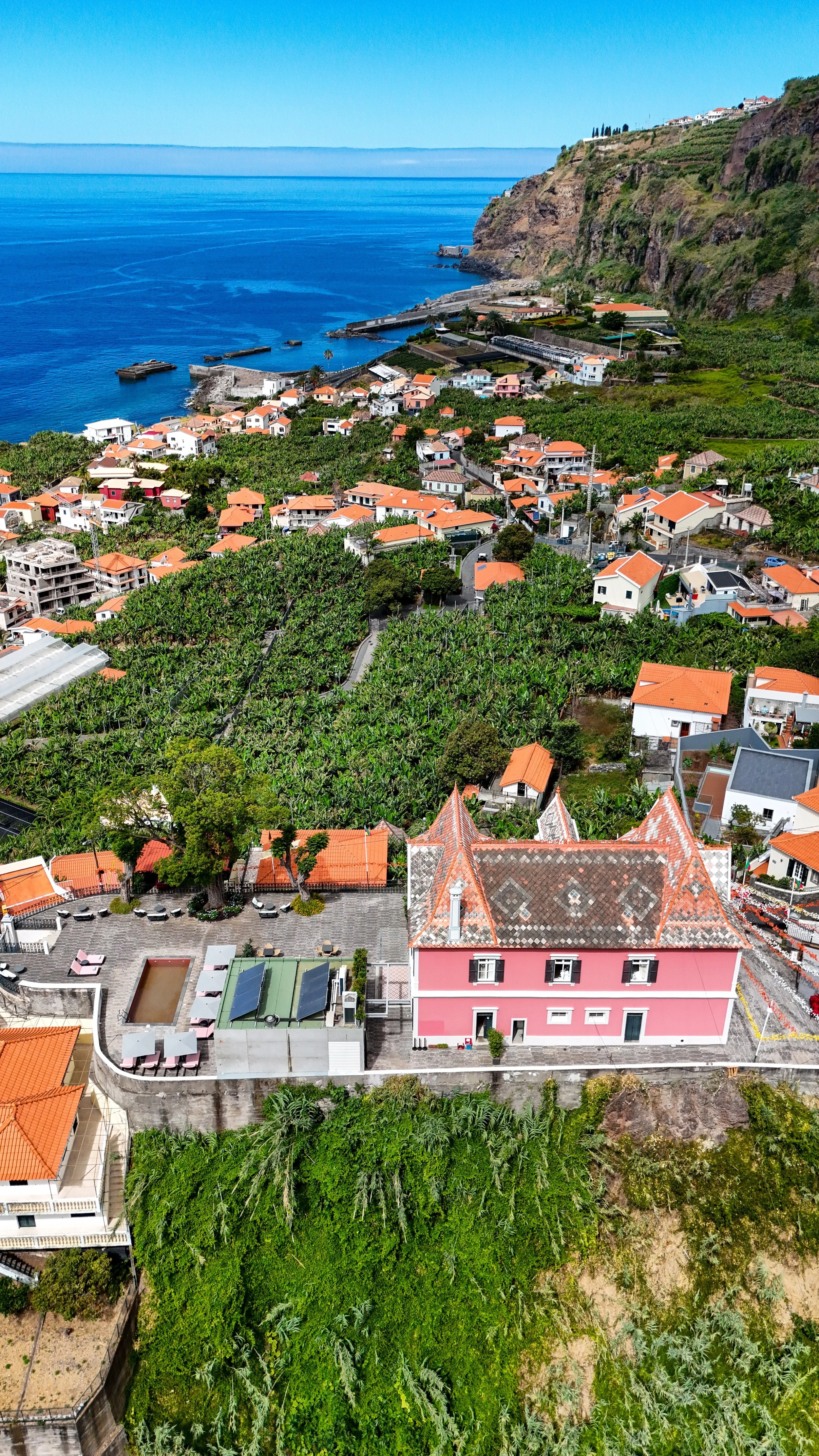 Panoramic aerial view overlooking the boutique hotel, Madeira coastline, and surrounding hillside landscape