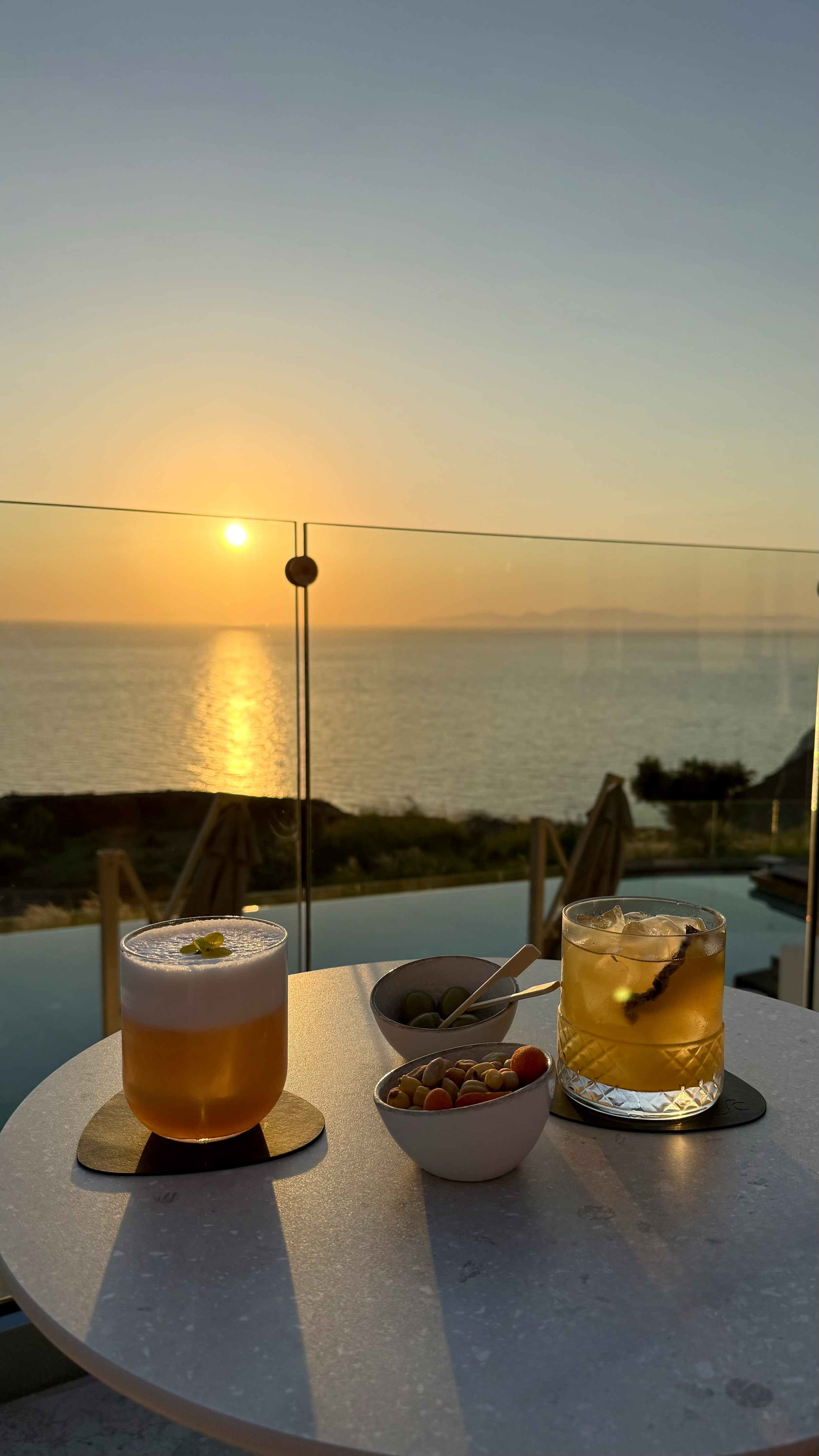 Signature sunset cocktails overlooking the Aegean Sea with an infinity pool and breathtaking Santorini views