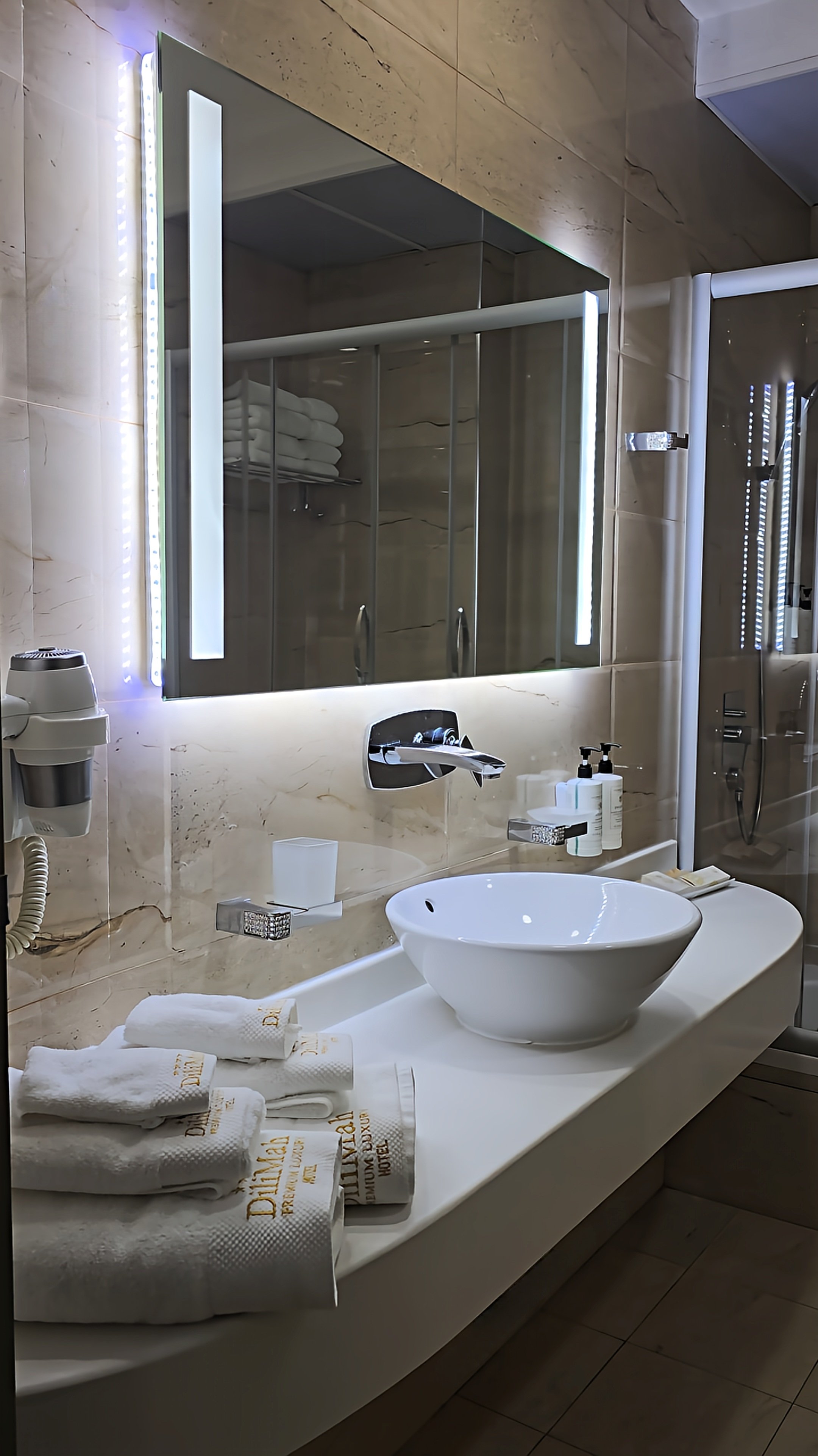 Modern marble bathroom with illuminated mirror and premium amenities at Dilimah Premium Luxury Hotel, Samarkand