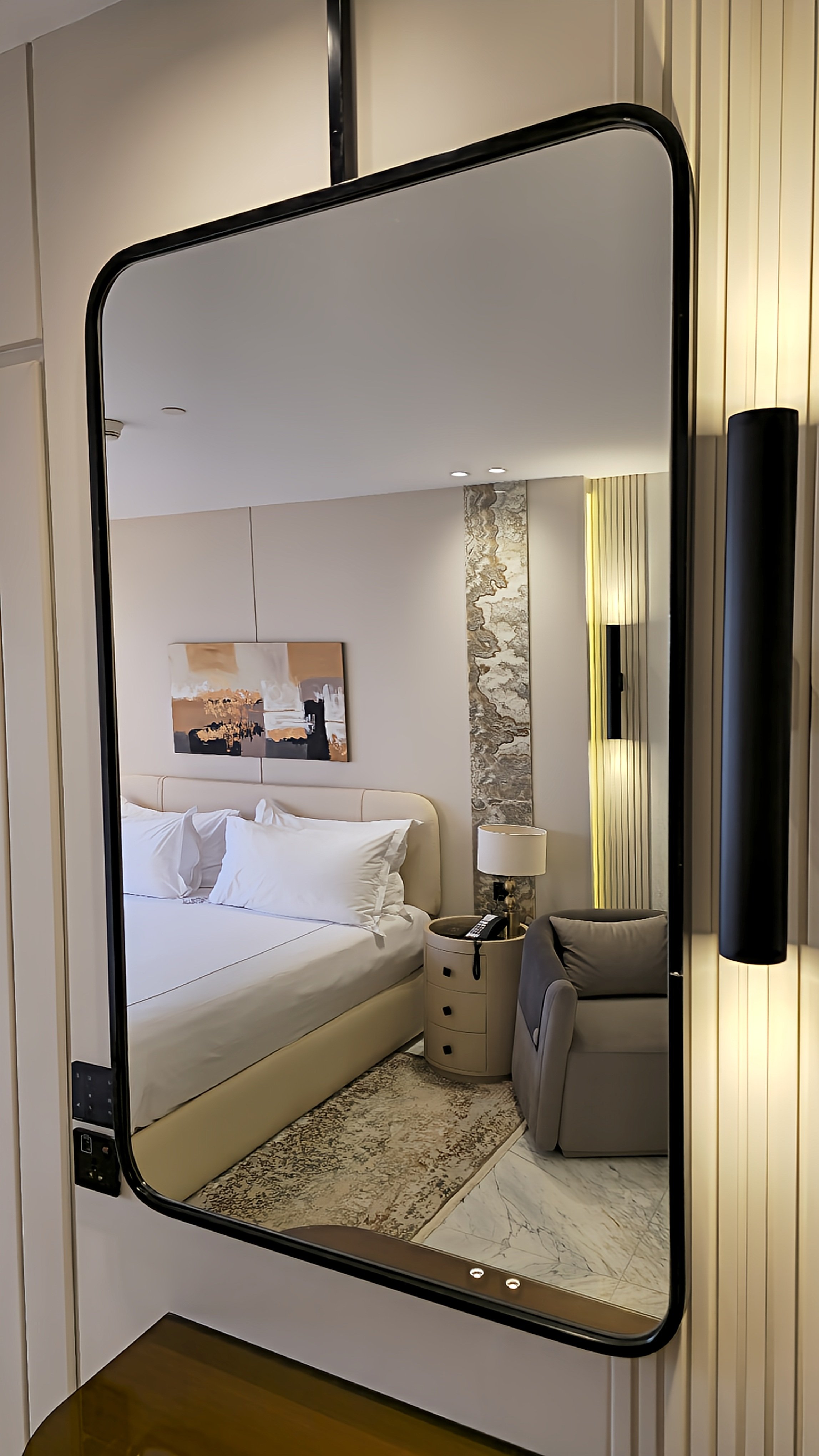 Modern suite reflected in a sleek mirror, featuring neutral tones, marble flooring, and contemporary décor, Sonesta St. George Hotel Luxor.
