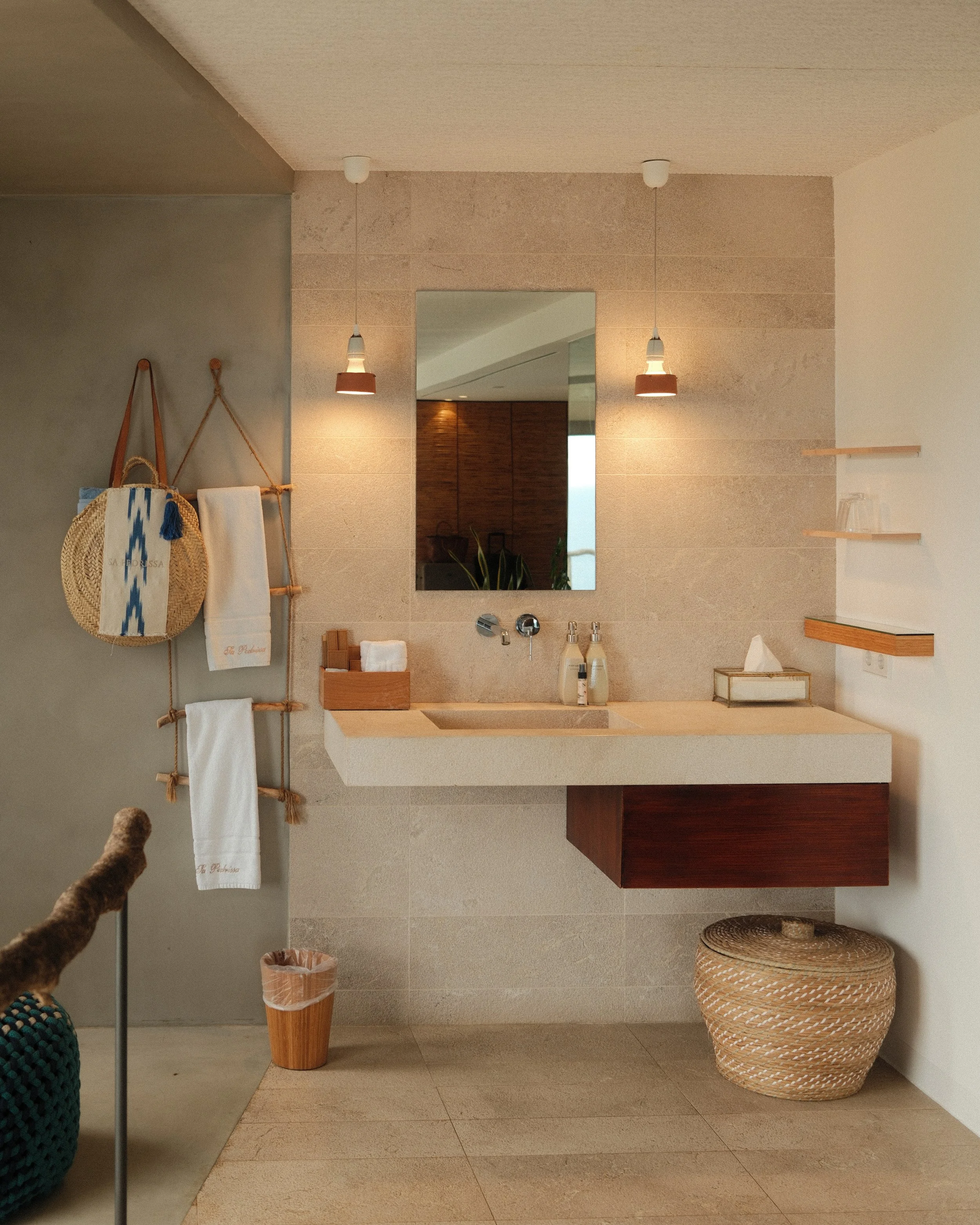 Elegant bathroom with natural stone finishes, warm wood accents and bespoke amenities at Sa Pedrissa, Mallorca