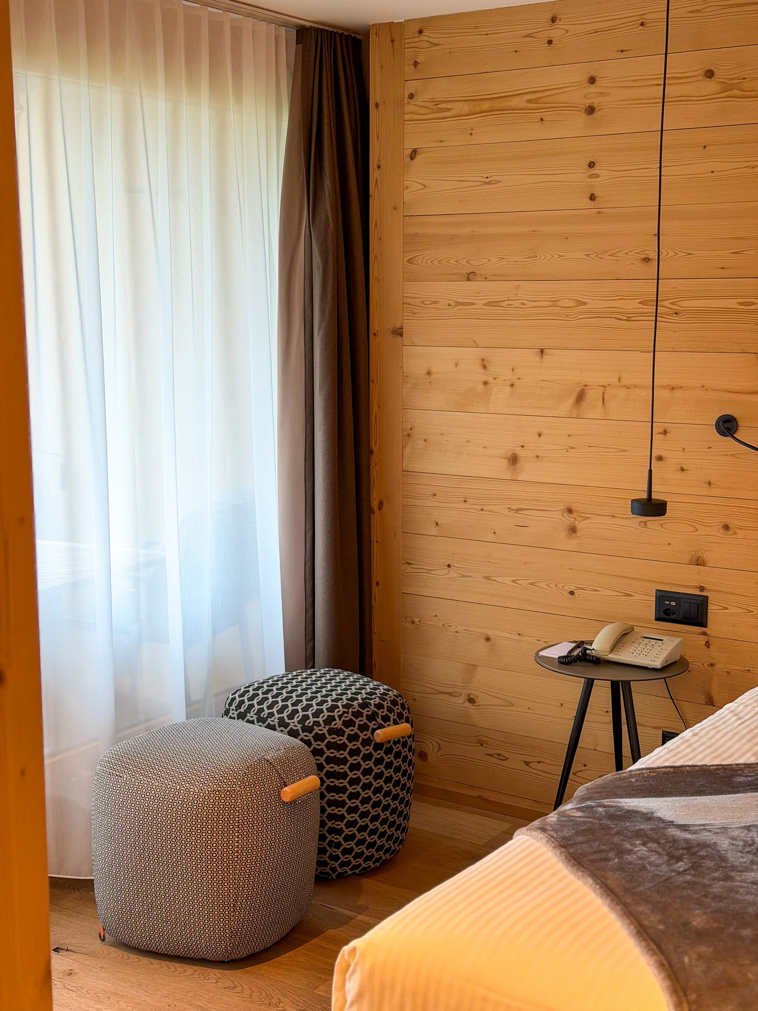 Cozy alpine guest room with natural wood interiors, soft lighting and mountain-inspired design at Eiger Mountain & Spa Soul Resort, Grindelwald