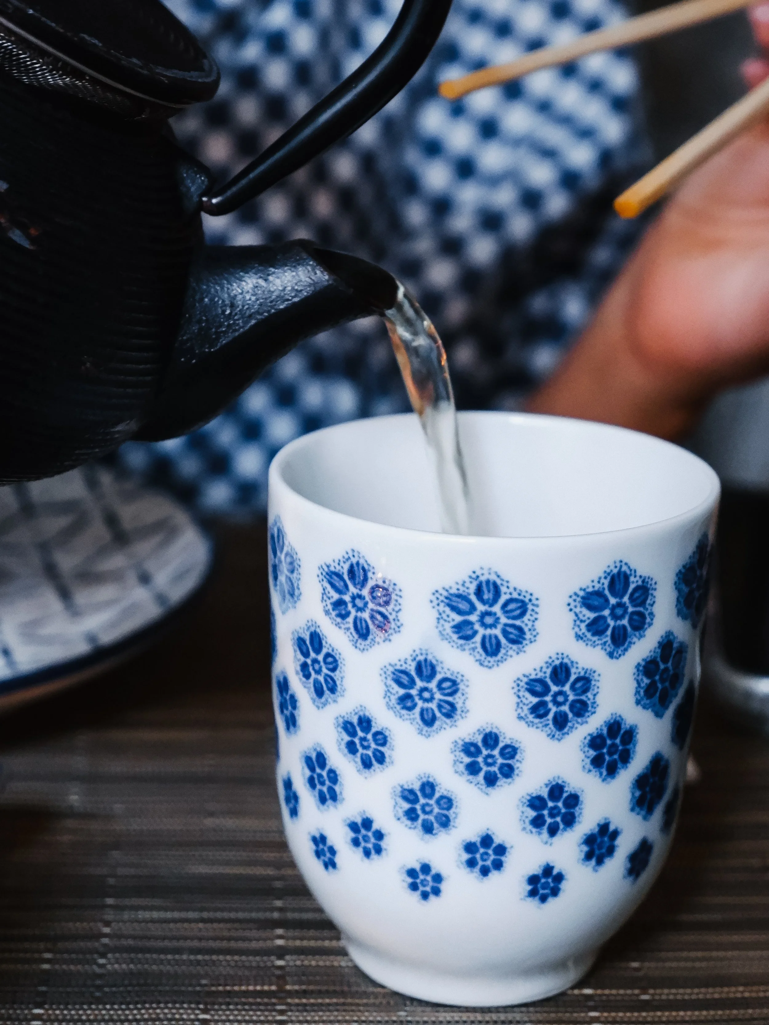 Freshly brewed Japanese tea poured into handcrafted ceramic cup during a relaxing meal