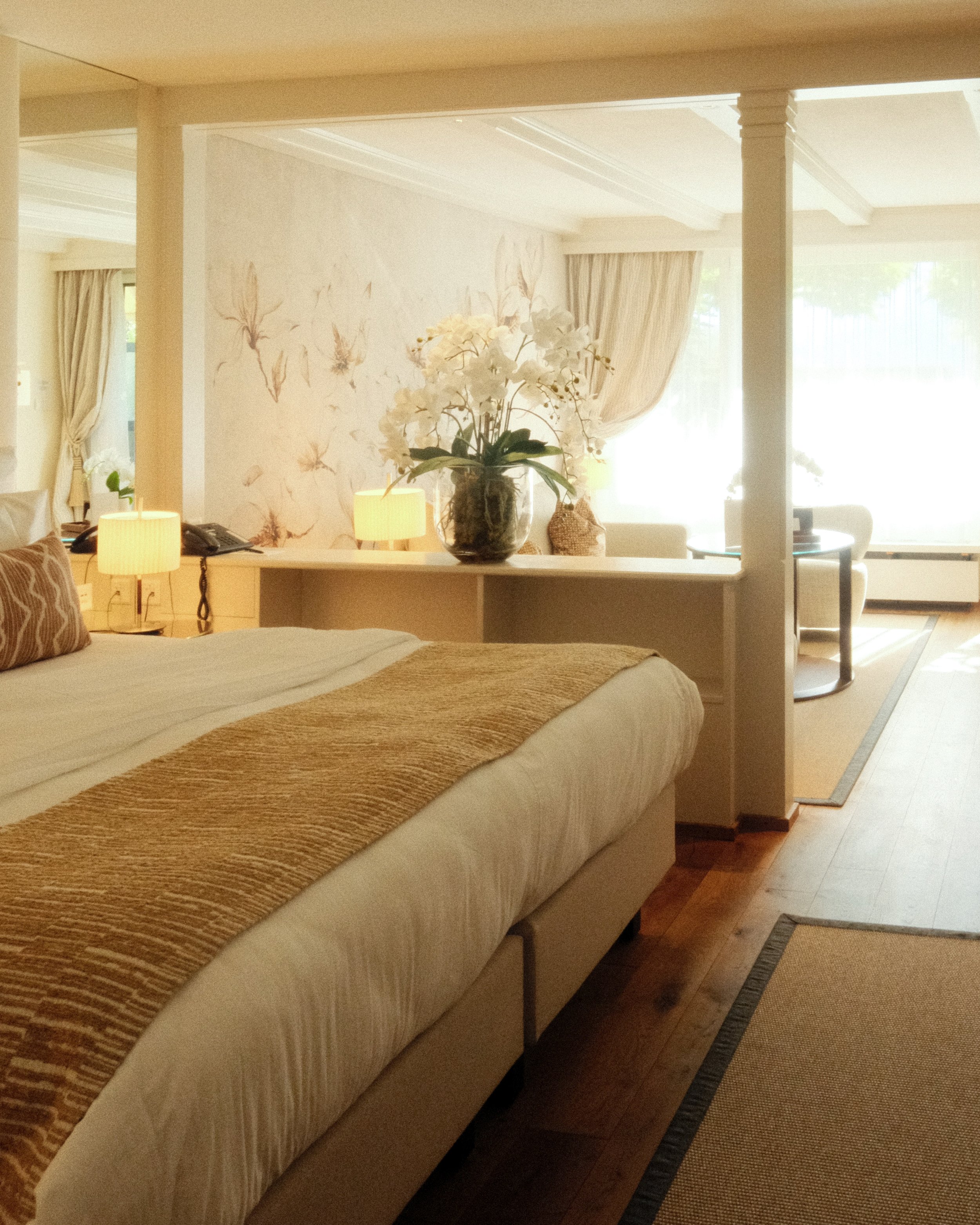 Spacious suite featuring elegant furnishings, warm wood floors, and a seating area