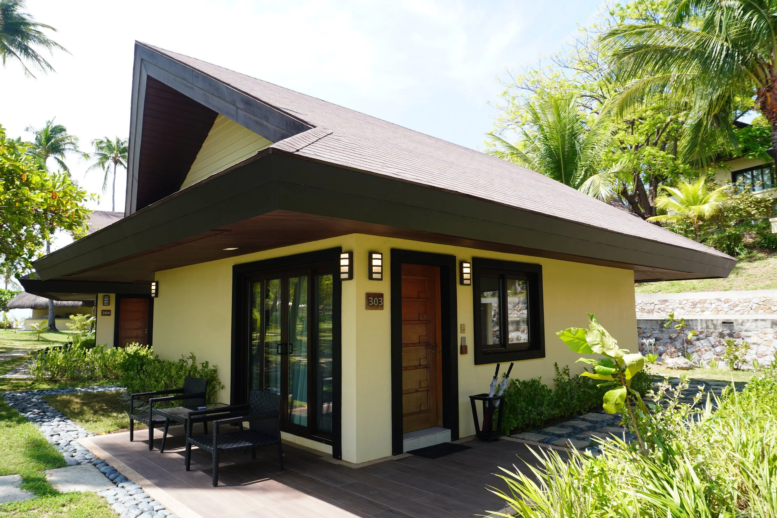 Modern beachfront villa surrounded by tropical gardens and lush landscaping