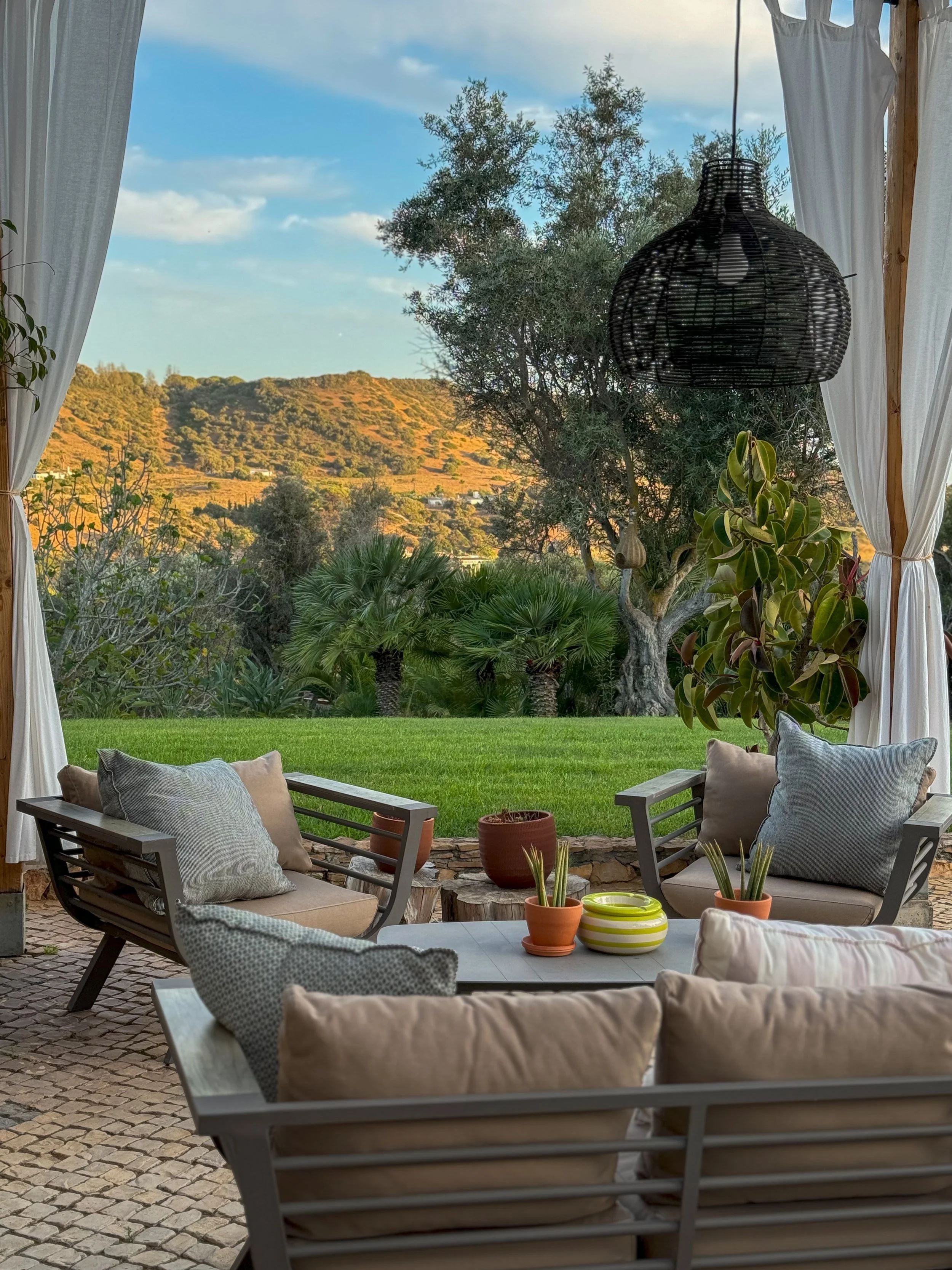 Outdoor lounge surrounded by lush gardens and peaceful countryside at Vila Valverde