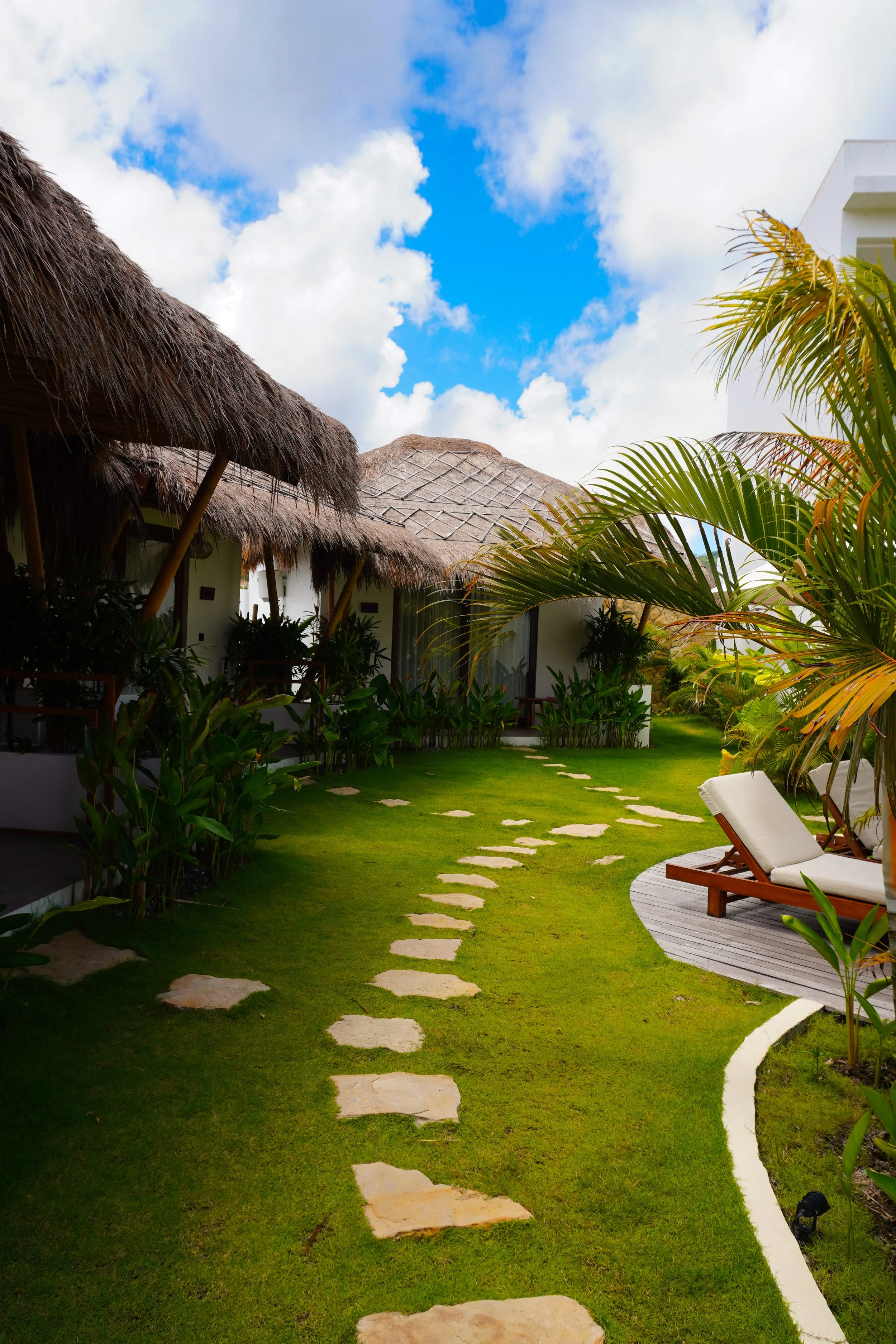 A path through greenery leading to private villas, blending seamlessly into the tropical landscape, Uryah Hotel Lombok – Lombok, Indonesia.