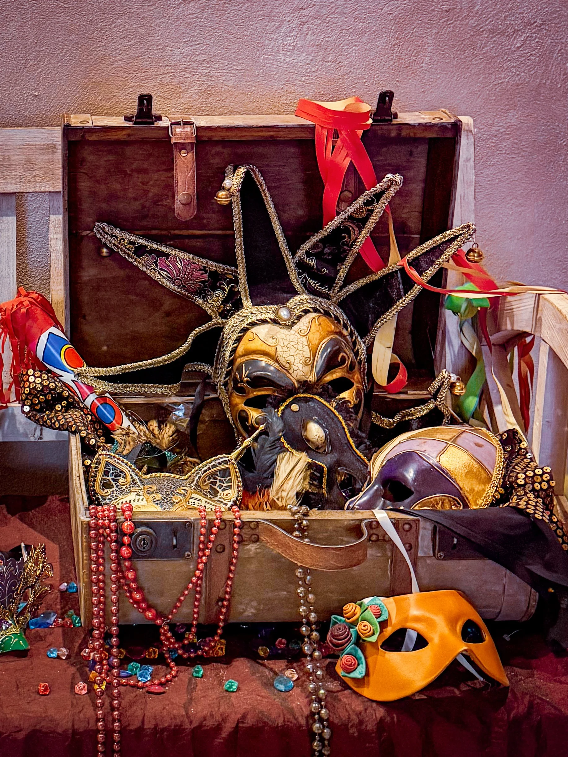 Venetian masks and antique trunk display reflecting artistic interior details, Art Hotel Commercianti – Bologna, Italy