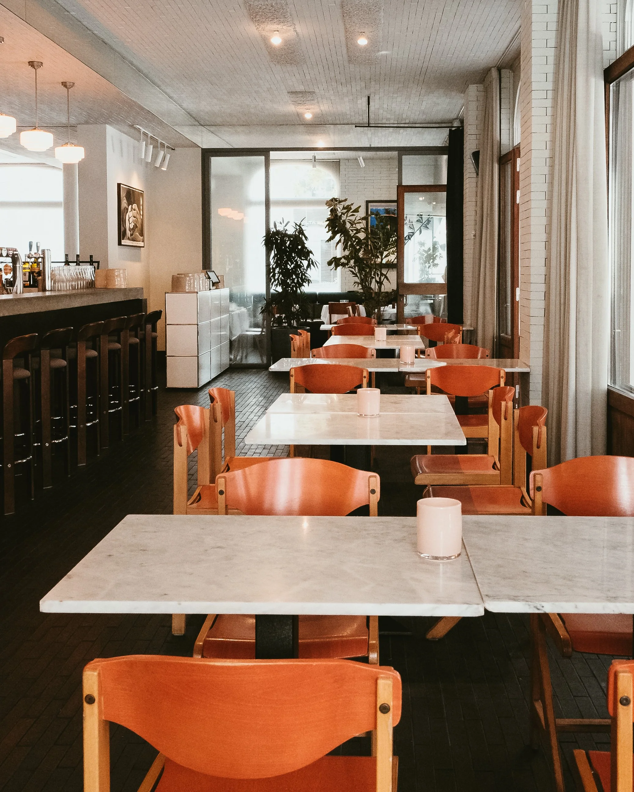 Bright restaurant with marble tables, designer furniture, and an inviting all day dining atmosphere