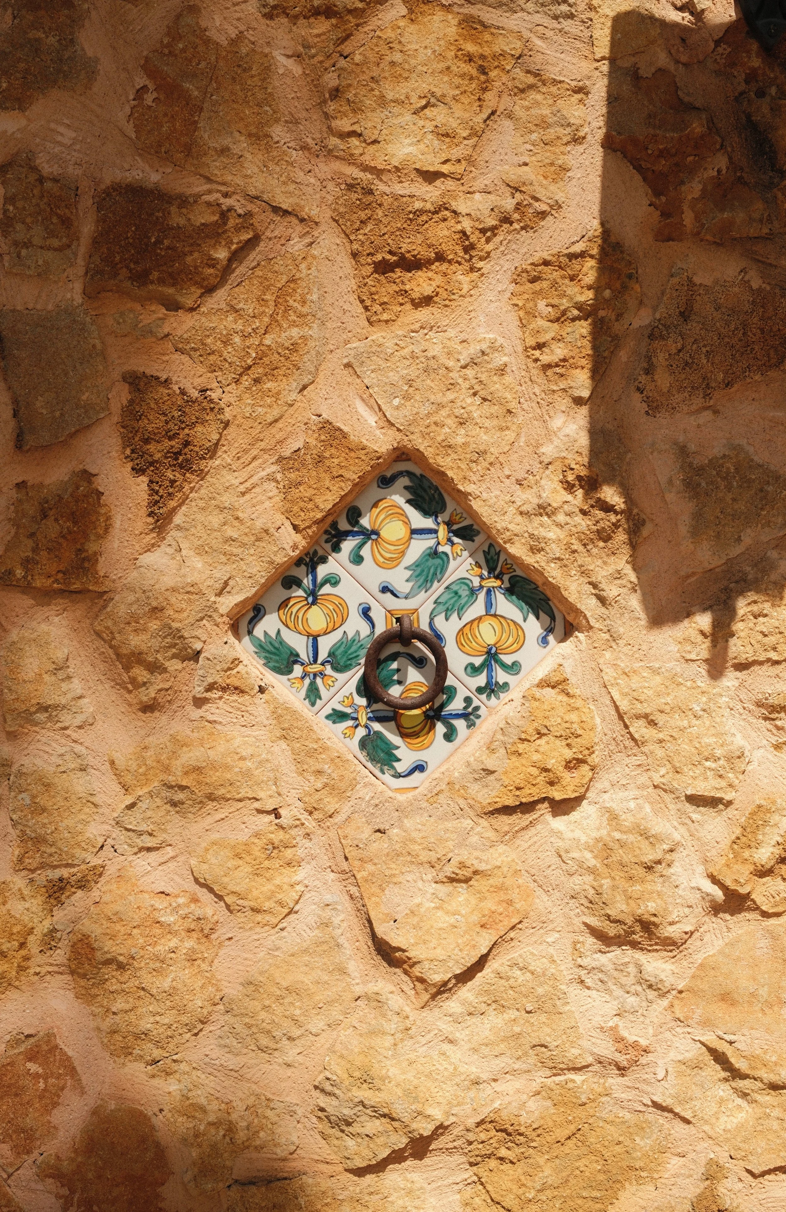 Traditional Mallorcan stone wall featuring handcrafted ceramic tile details at Son Molí Country House