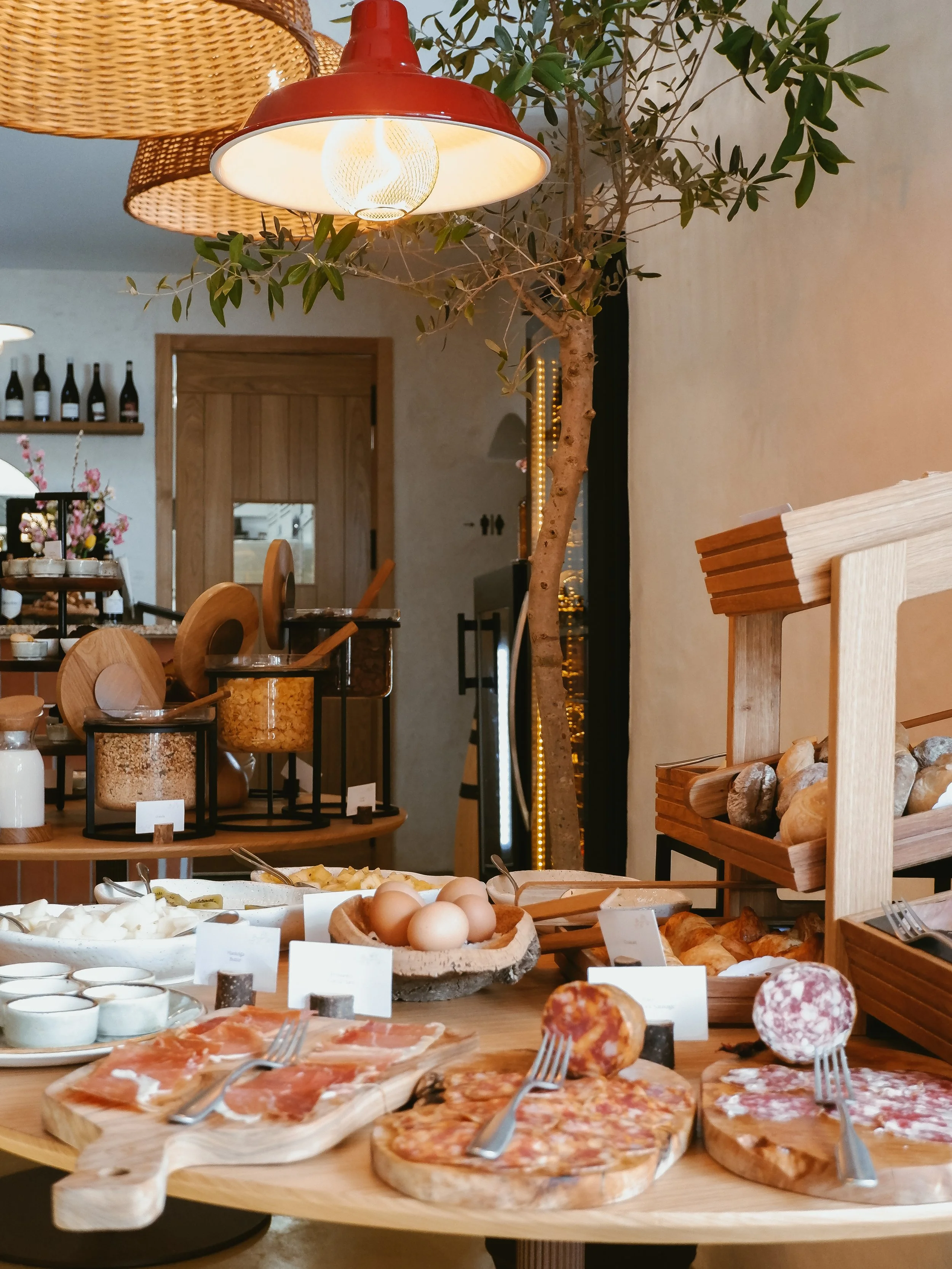 Breakfast buffet with local cured meats, fresh bread, pastries, eggs, cereals, and regional products