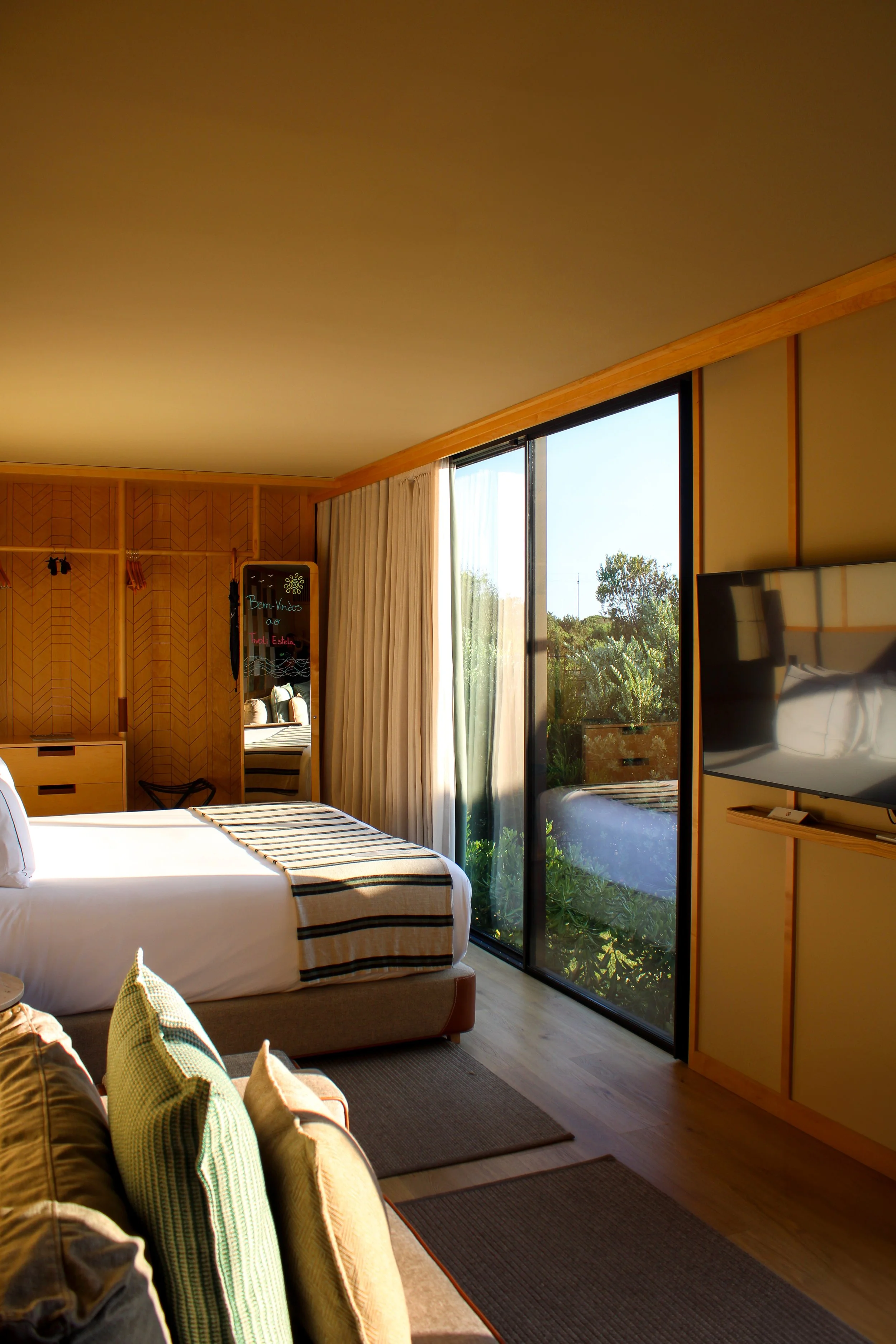 Contemporary guest room with floor-to-ceiling windows and garden views
