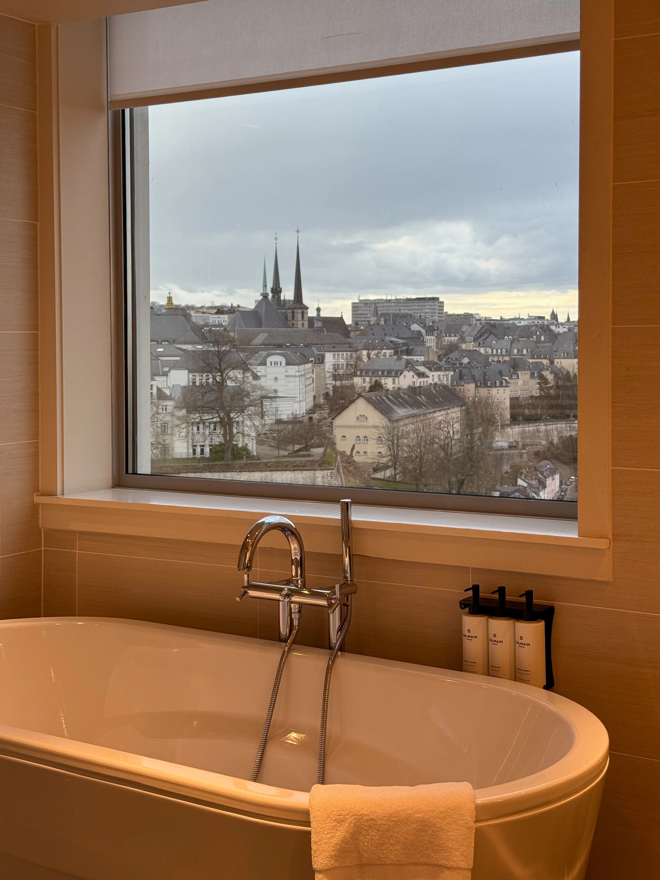Freestanding bathtub overlooking the historic skyline of Luxembourg City from a luxury suite at Sofitel Le Grand Ducal
