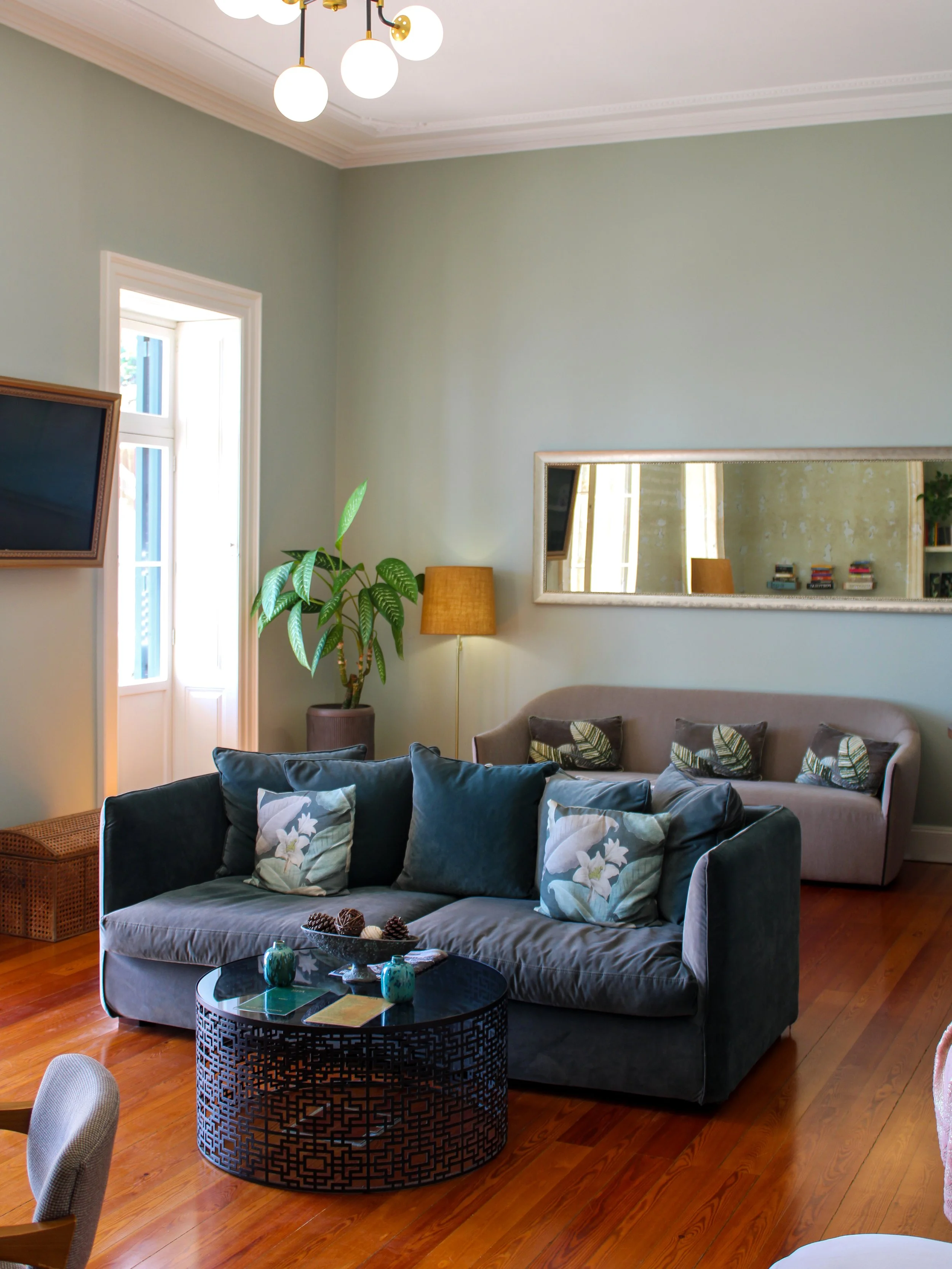 Spacious heritage lounge with elegant furnishings, high ceilings, and natural wooden floors