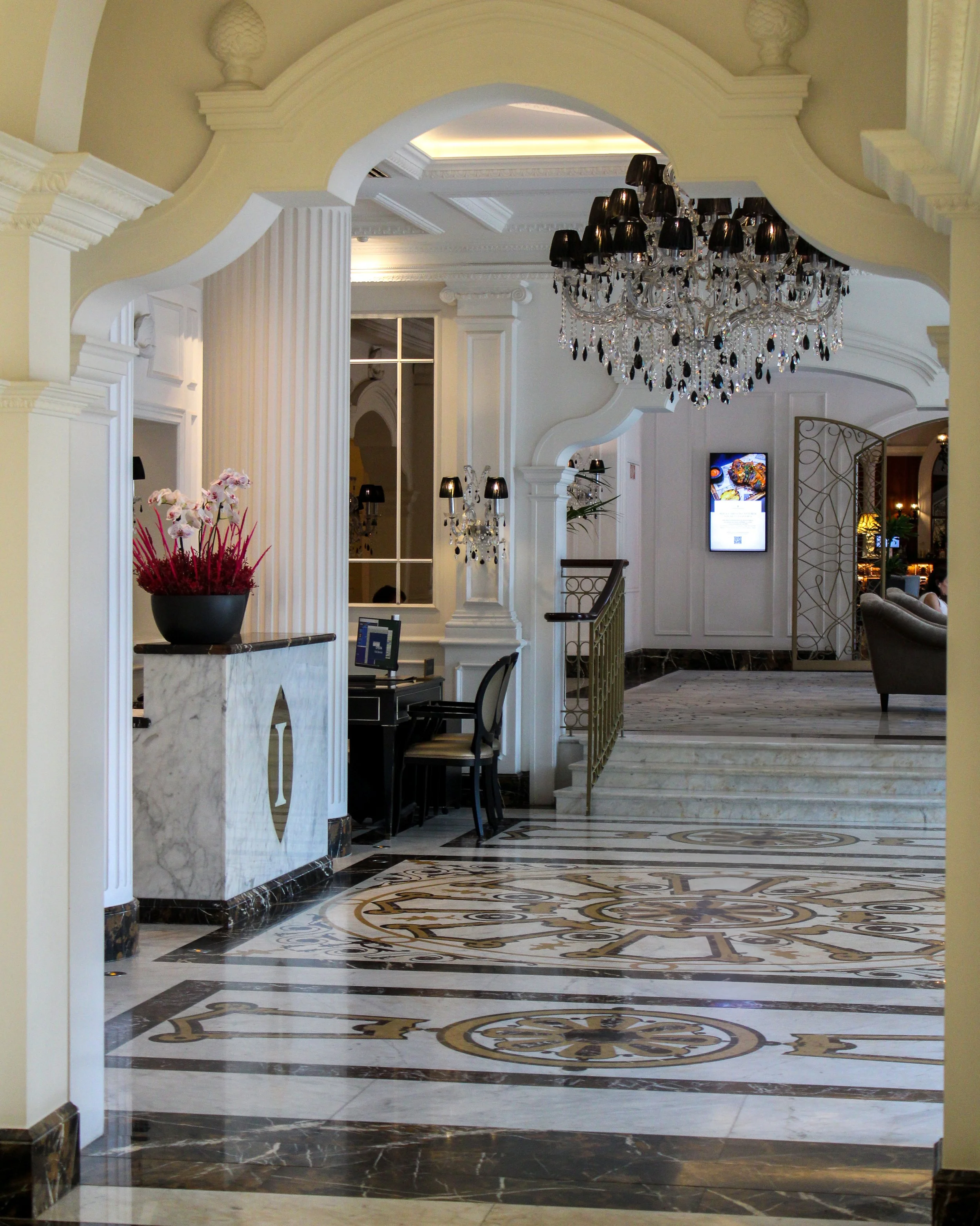 Grand lobby showcasing marble floors, chandeliers, and classical design