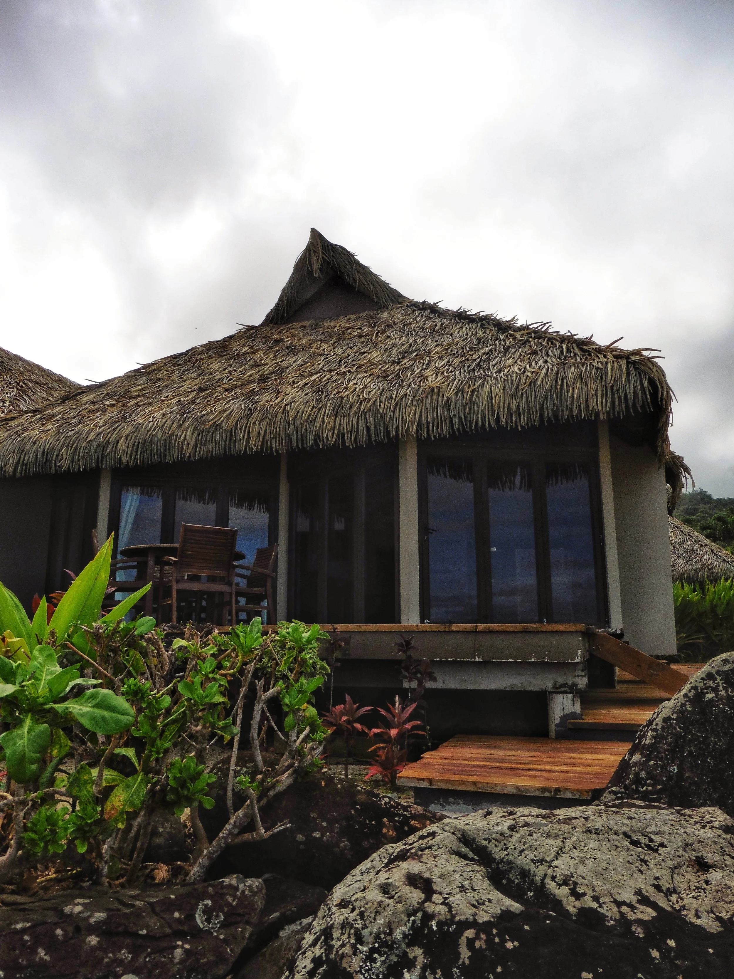 Polynesian-style beachfront villa with thatched roof at Sea Change Villas in Rarotonga