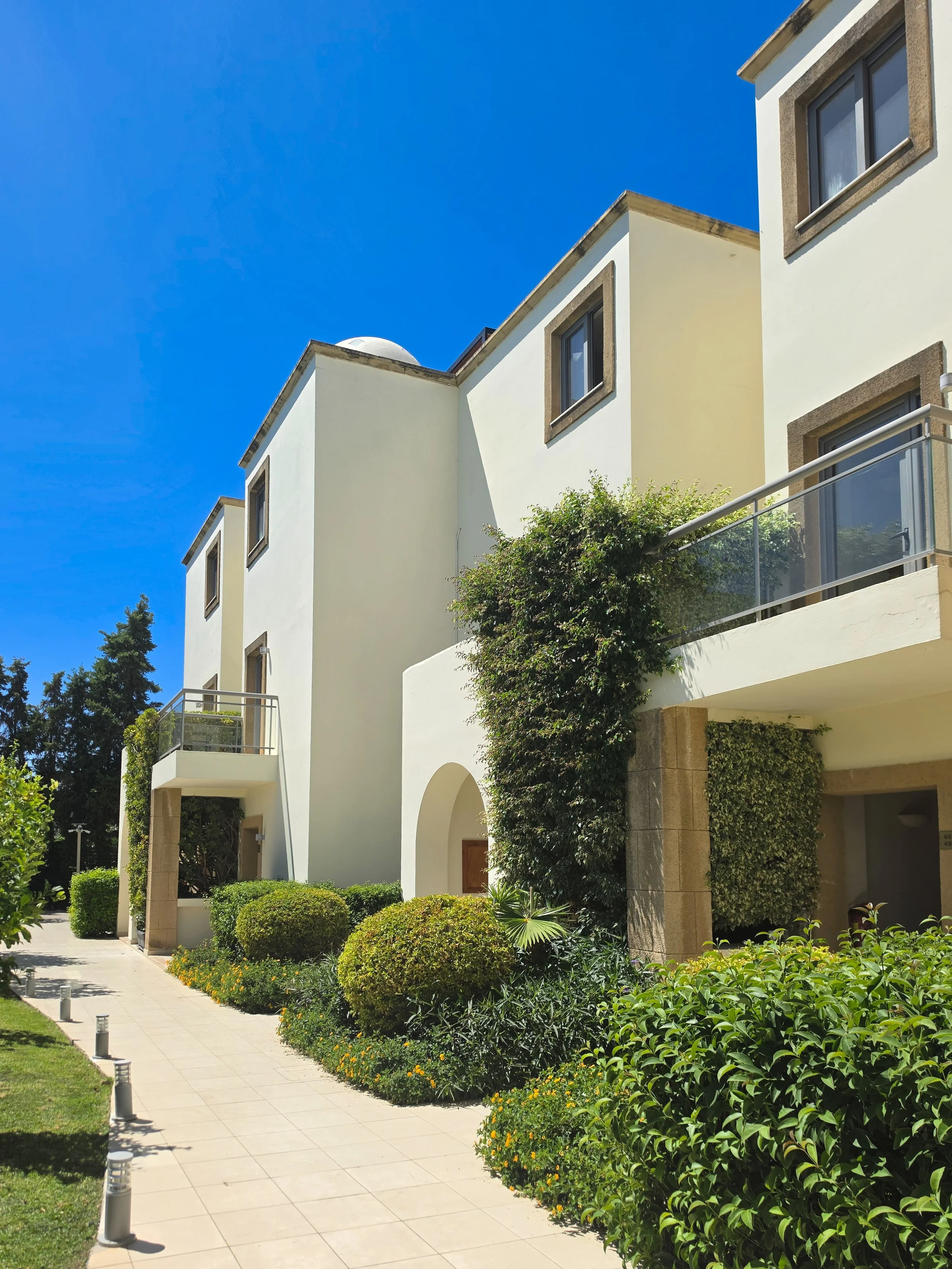 Beautiful resort pathways surrounded by lush Mediterranean gardens and contemporary villas