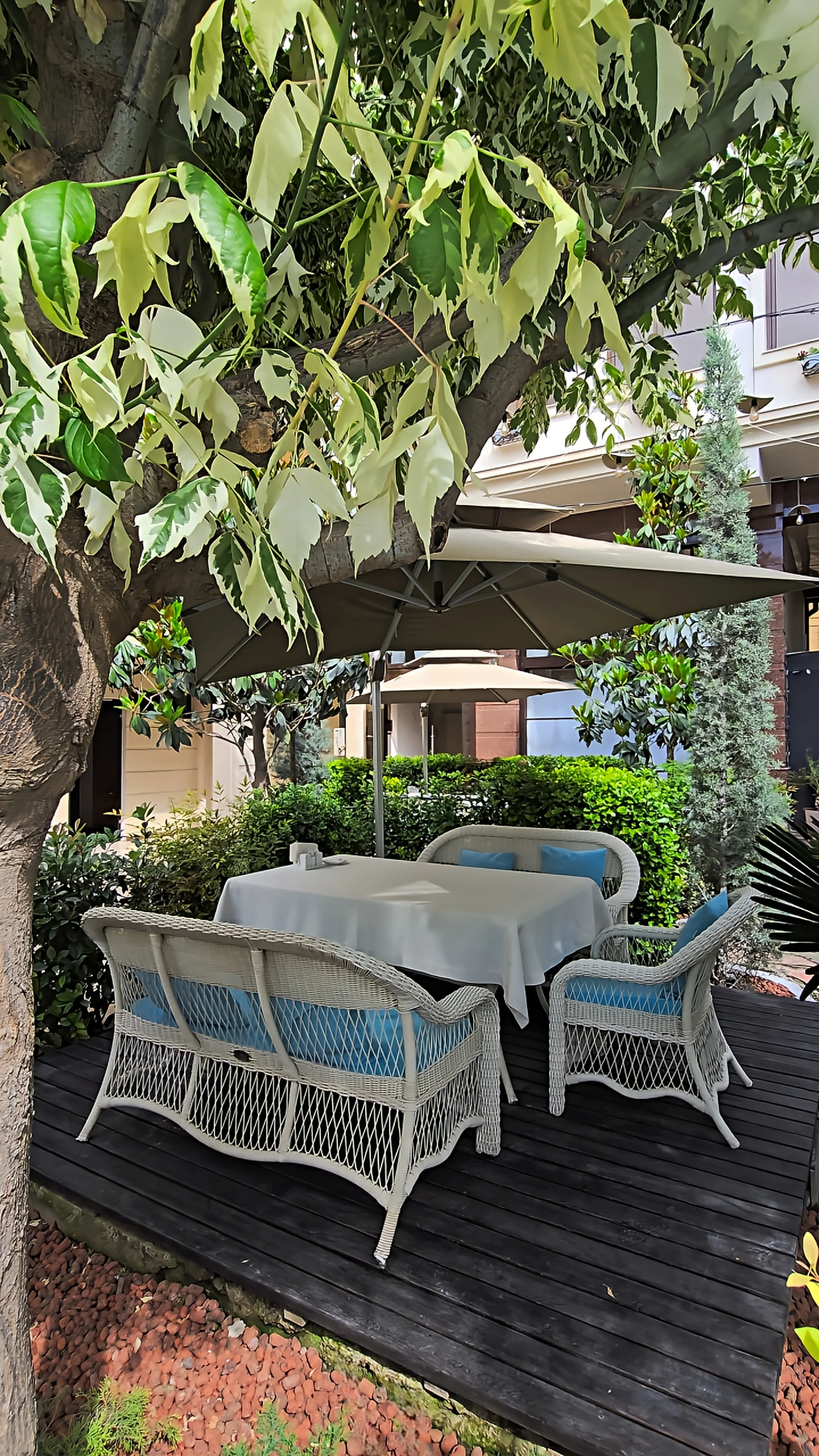 Private garden dining terrace surrounded by greenery and shaded seating at Dilimah Premium Luxury Hotel, Samarkand, Uzbekistan
