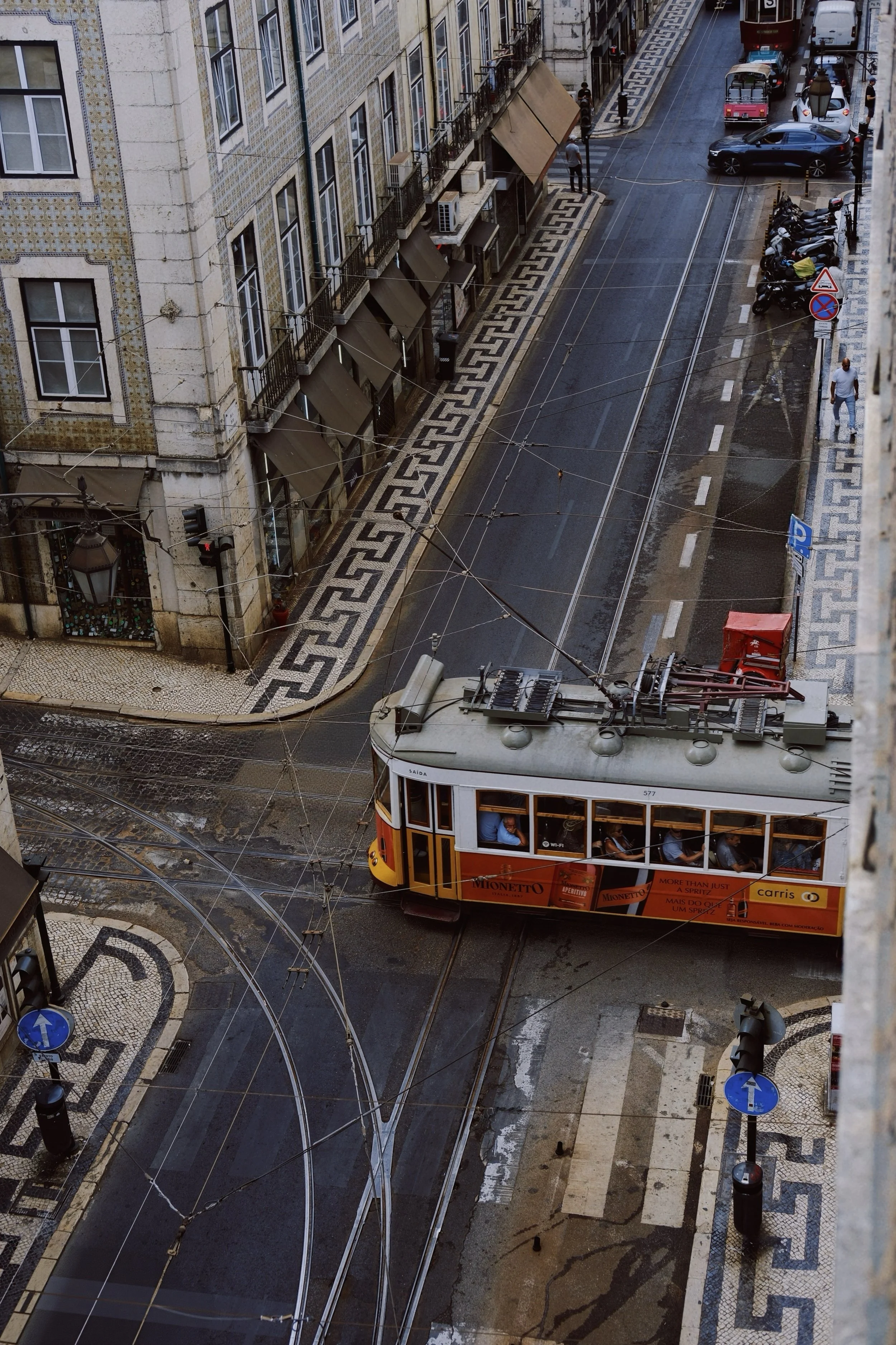 Classic Lisbon tram passing through Baixa streets viewed from above